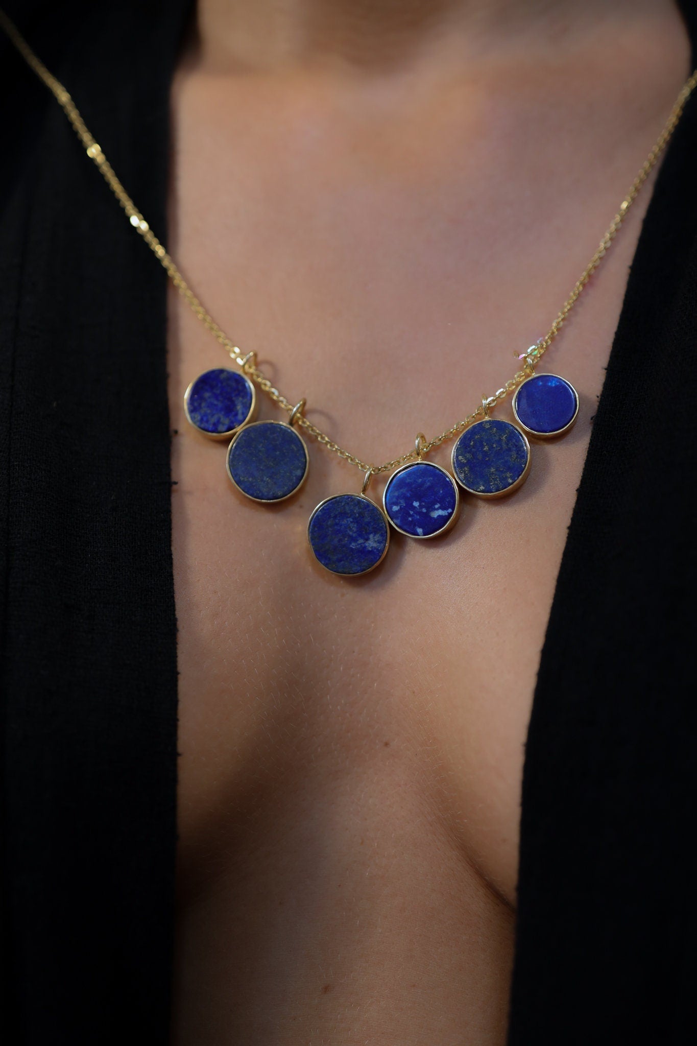 Lapis Lazuli pendant shown worn with matching blue stones, featuring a compact round shape and gold-plated sterling silver setting.