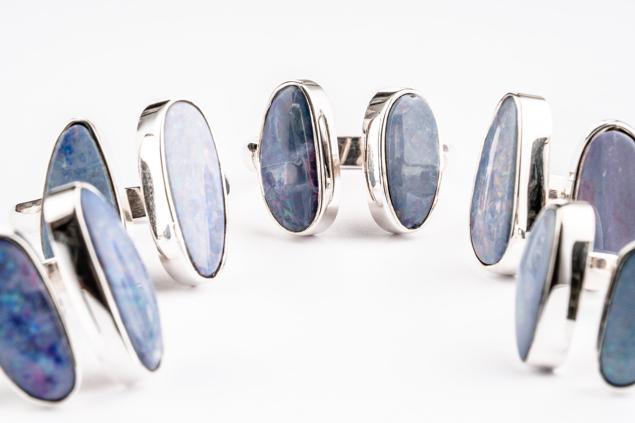Australian Opal Doublet Adjustable Ring shown on white background with two angled opals hugging the finger shape.