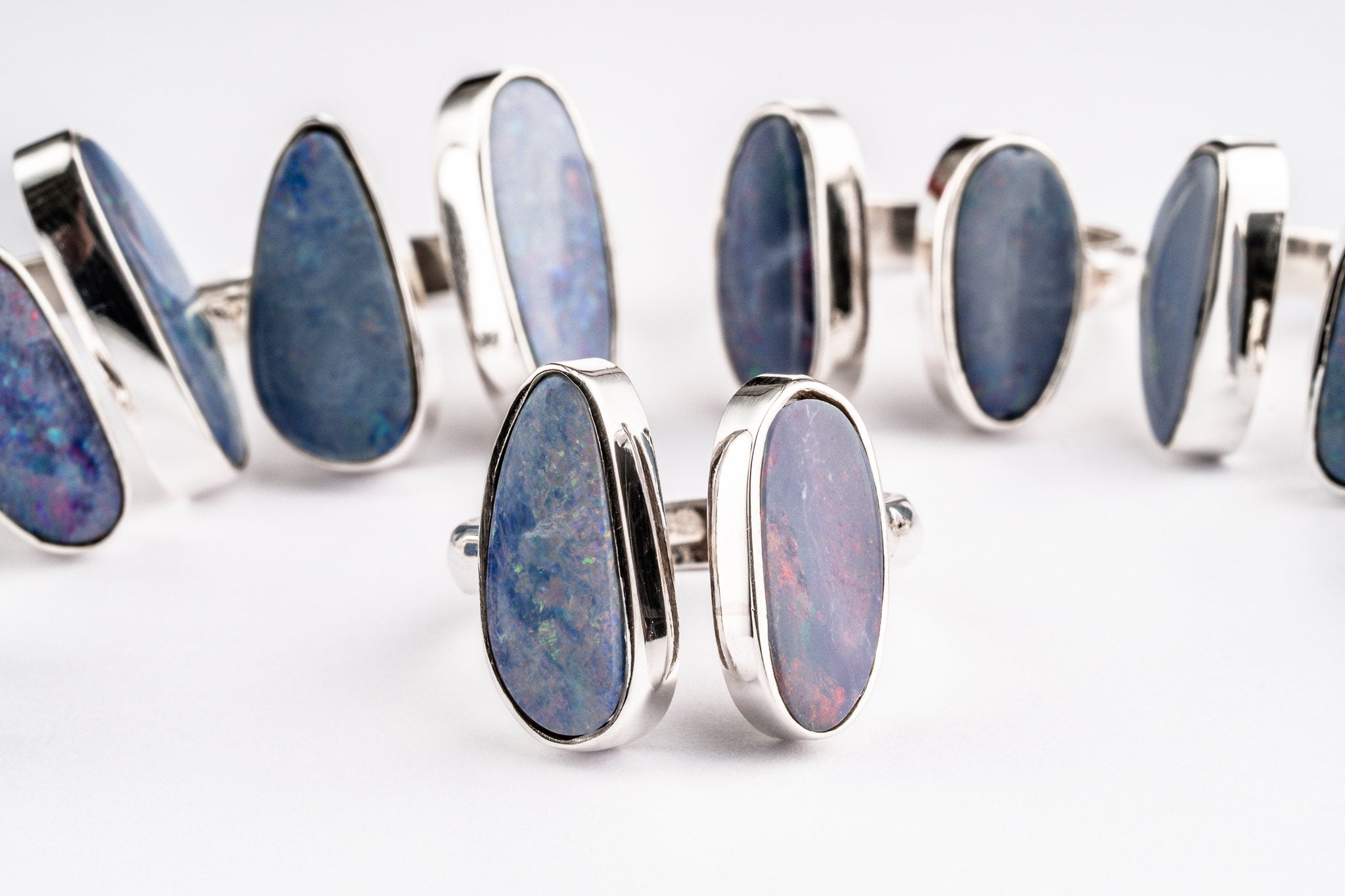 Australian Opal Doublet Adjustable Rings shown on white background with vintage cut opals and polished silver bands.