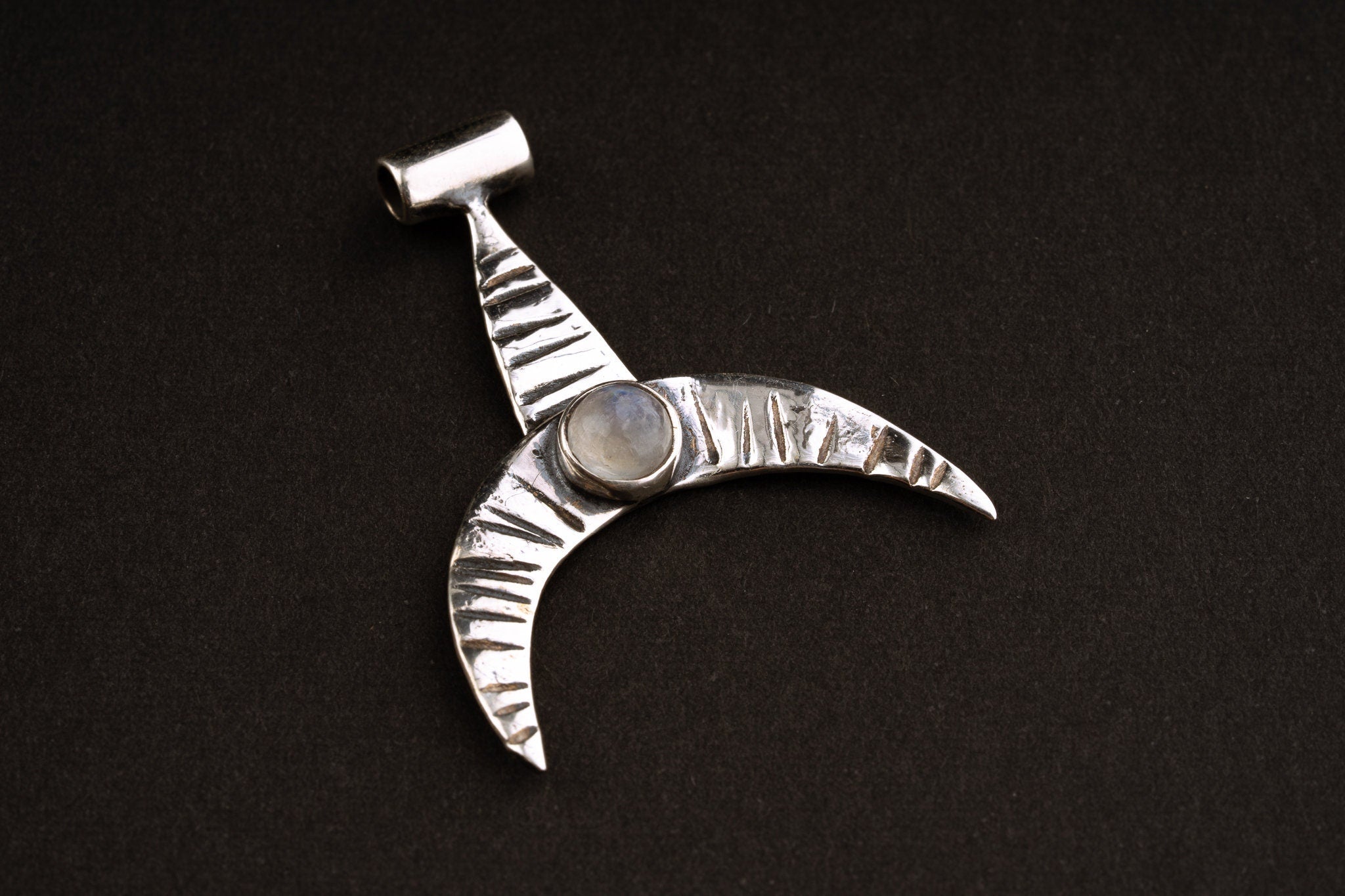 Crescent Whale Moonstone pendant shown on dark background with oxidized sterling silver and Blue Moonstone accent.