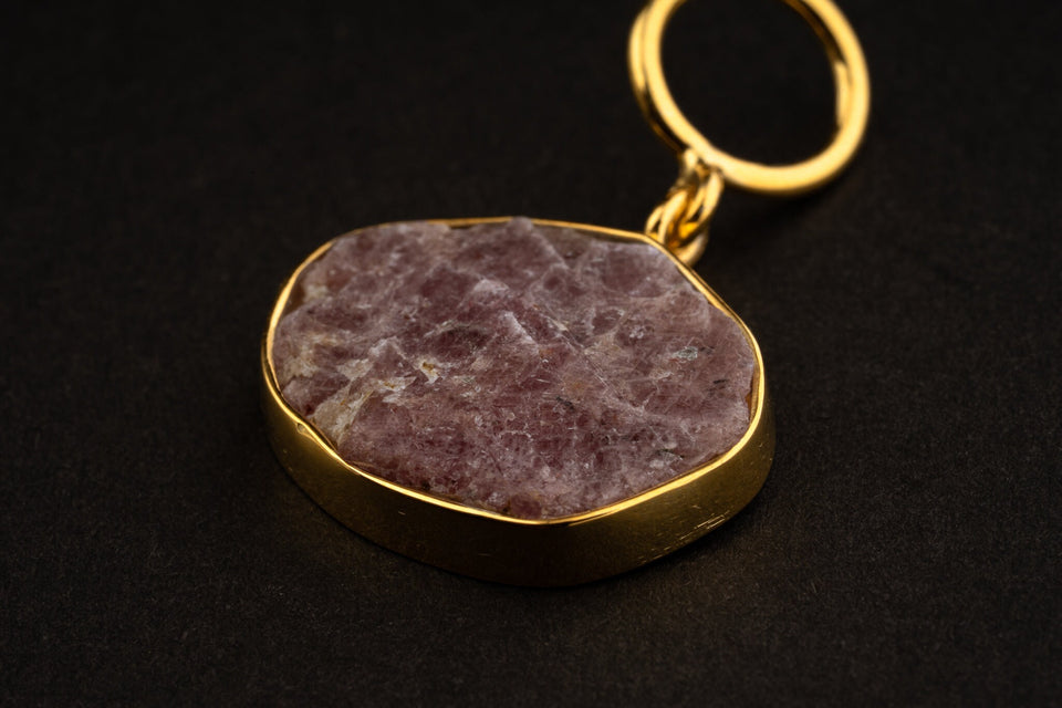 Close-up of raw Ruby record keeper pendant with gold-plated silver cap, wide bail, mica inclusions, and earthy red mineral texture.