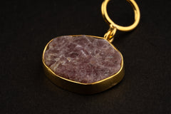 Close-up of raw Ruby record keeper pendant with gold-plated silver cap, wide bail, mica inclusions, and earthy red mineral texture.