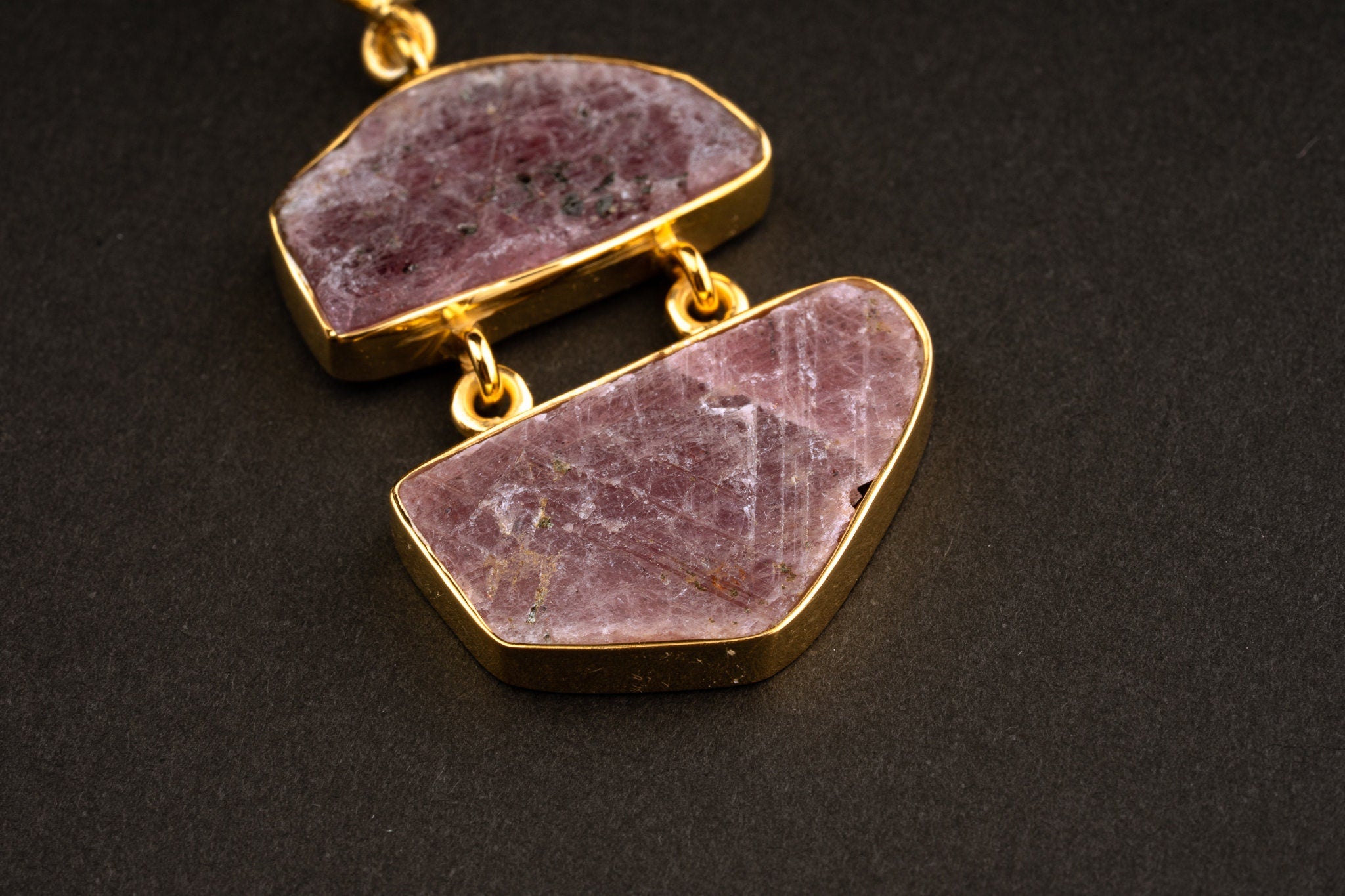 Detail view of two linked raw Ruby stones in 16k gold-plated sterling silver, showing earthy red colour and mineral inclusions.