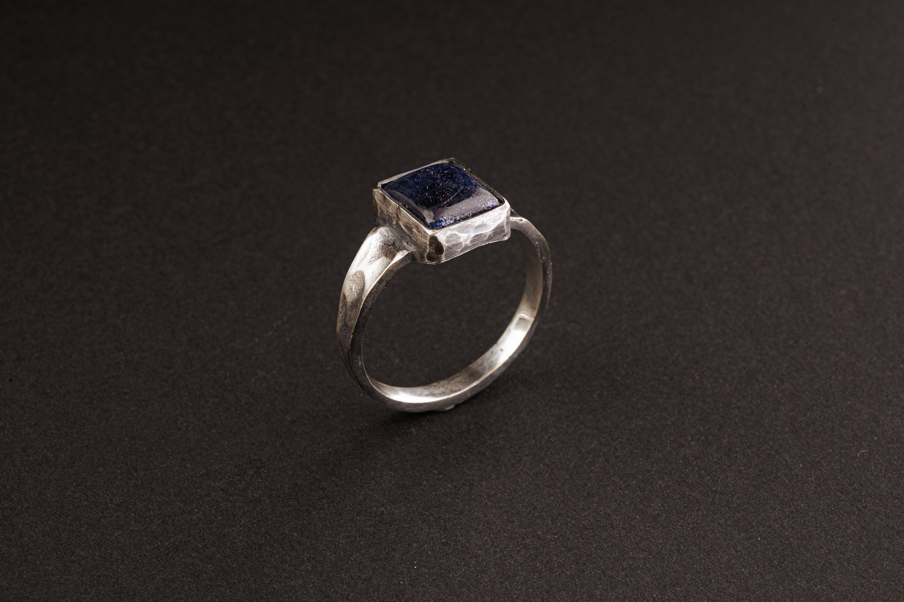 Side view of Tanzanite ring showing oxidized sterling silver texture, raised bezel setting, and masculine profile.