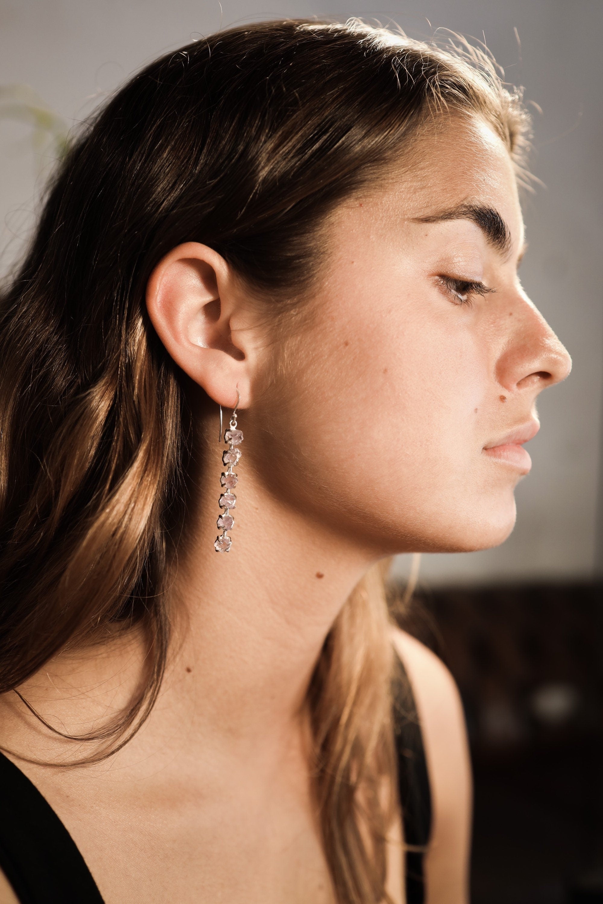 Six Stone Raw Amethyst earring shown worn on a model, highlighting lightweight movement and purple crystal chain.