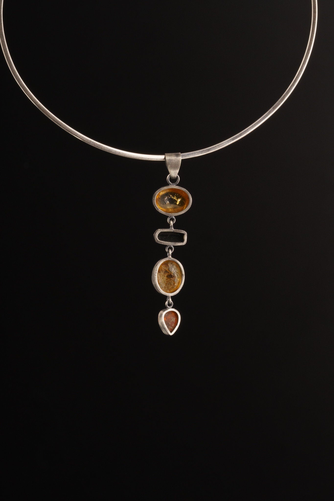 Ethiopian Opal Tourmaline Smoky Quartz Agate pendant shown on black background with vertical hinged stone structure.