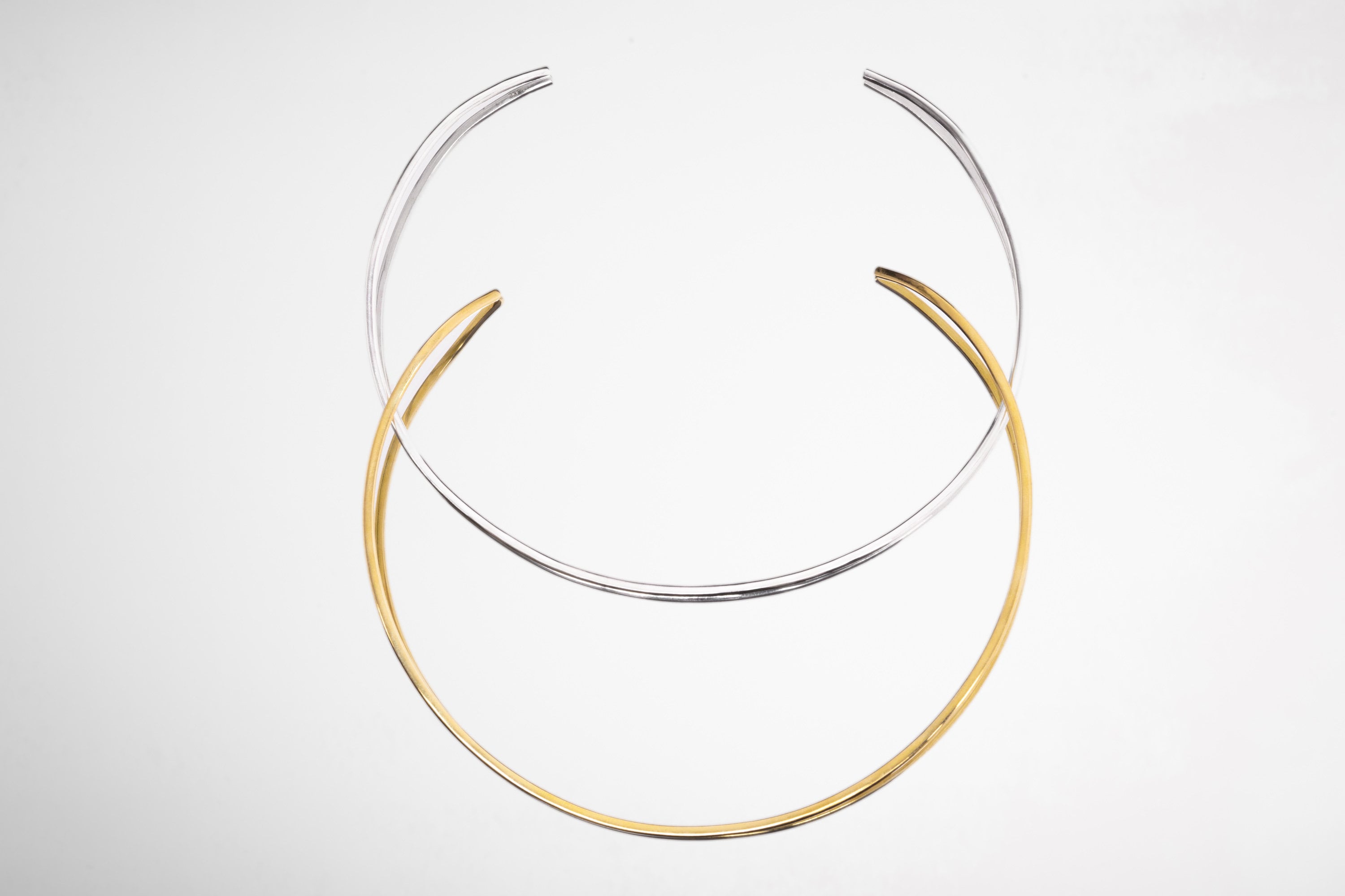 Silver and gold open collar chokers displayed together, showing handmade pendant base necklace options.