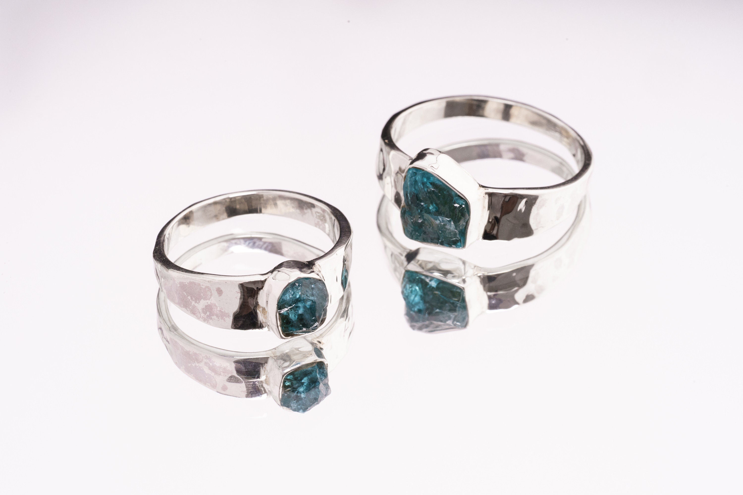 Group of Blue Apatite Textured Silver Rings shown on white background with handmade sterling silver bands.