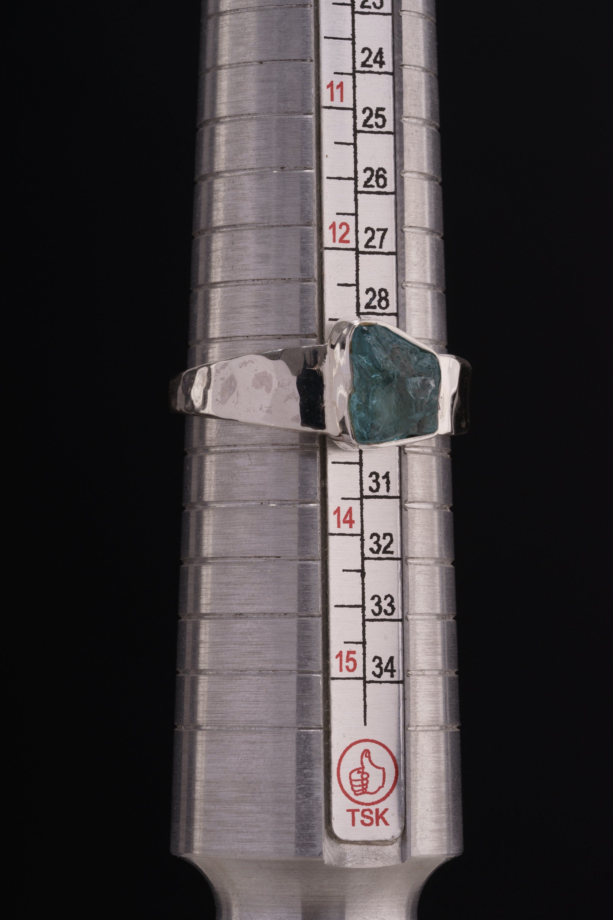 Blue Apatite Textured Silver Ring shown beside a ruler for scale with semi rough crystal and sterling silver setting.