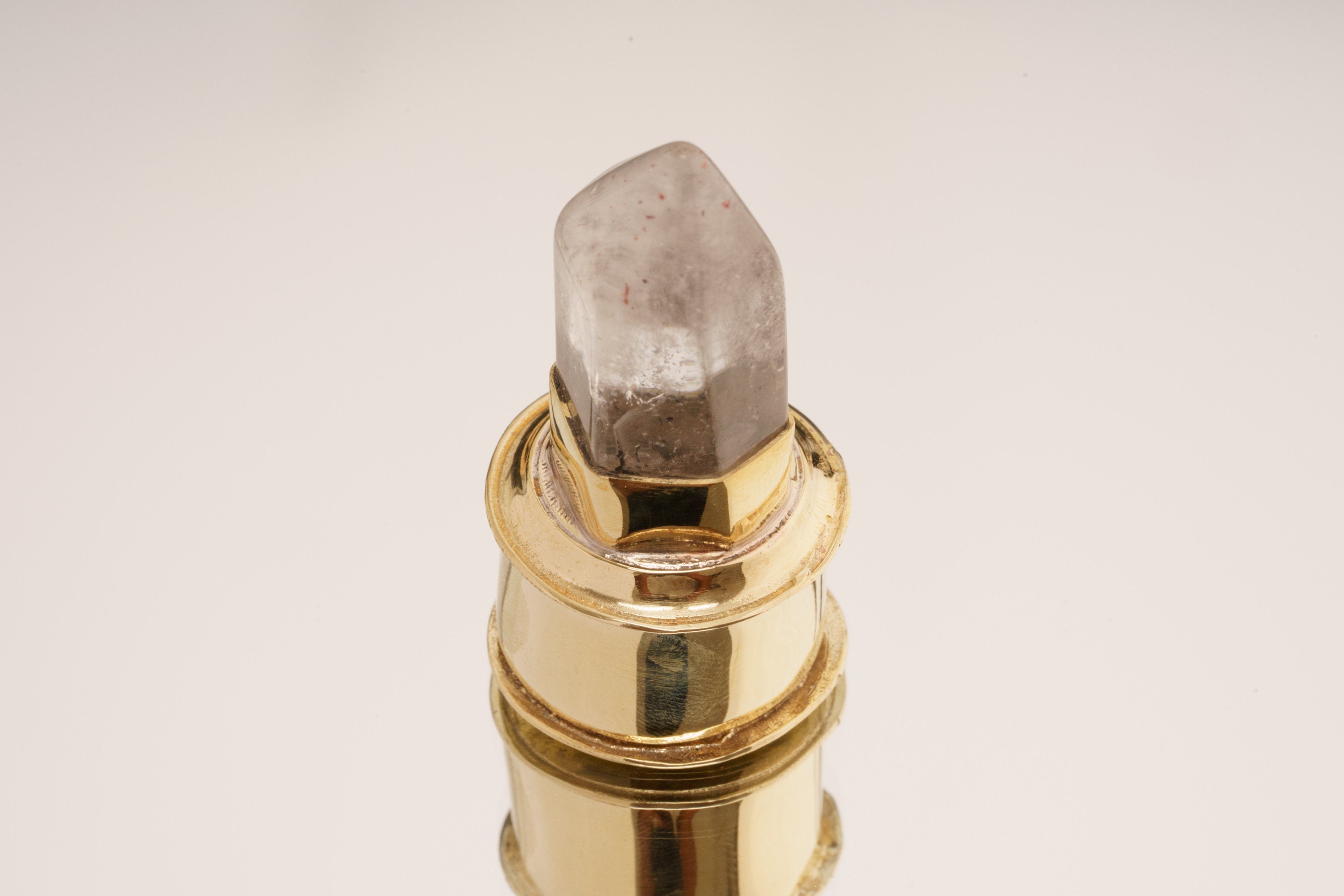 Rutilated Quartz capsule pendant shown standing upright with polished gold-plated brass body and crystal lid.