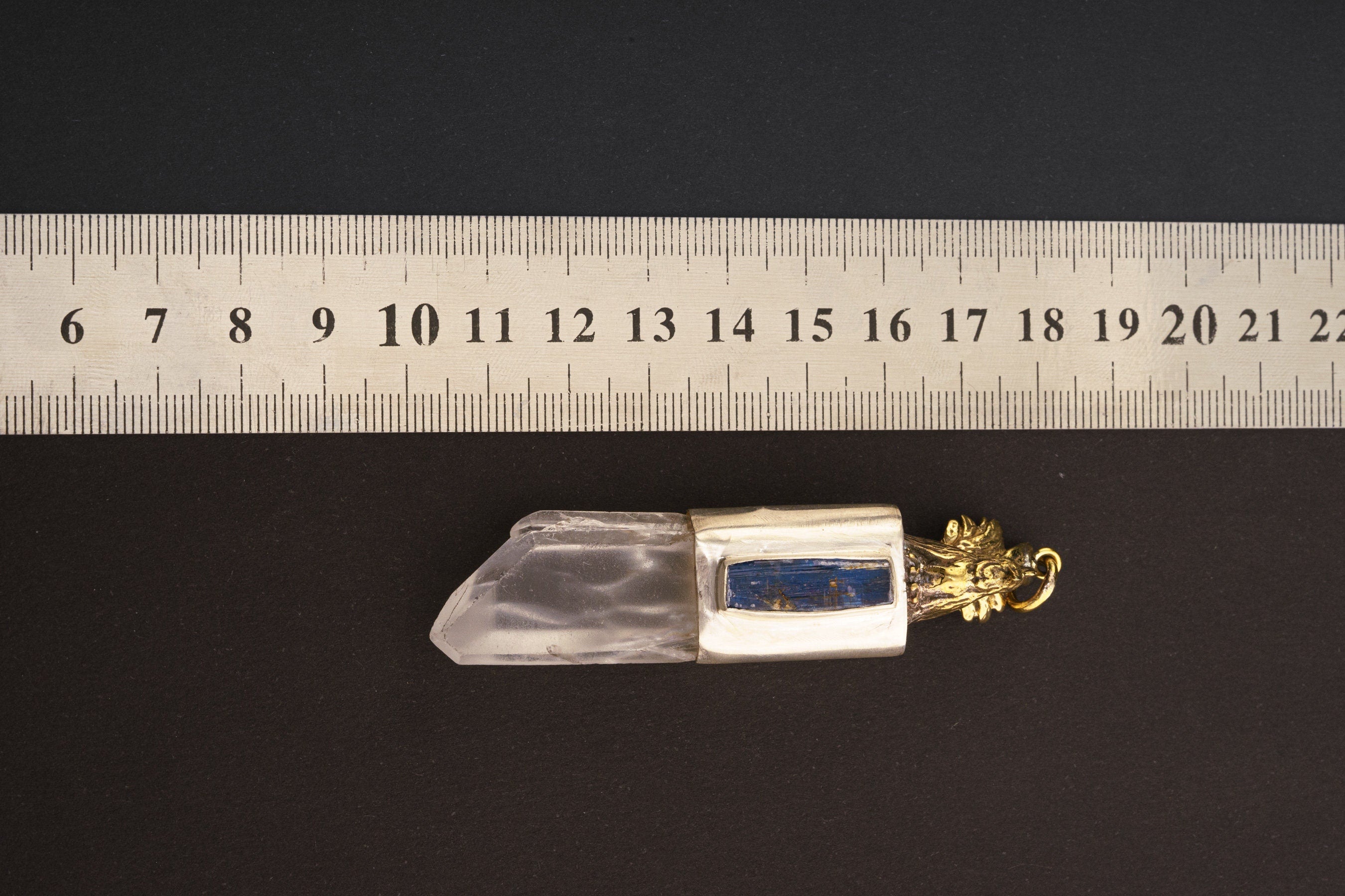 Rooster Twin Quartz Kyanite pendant shown beside a ruler for scale with brushed silver setting and brass detail.