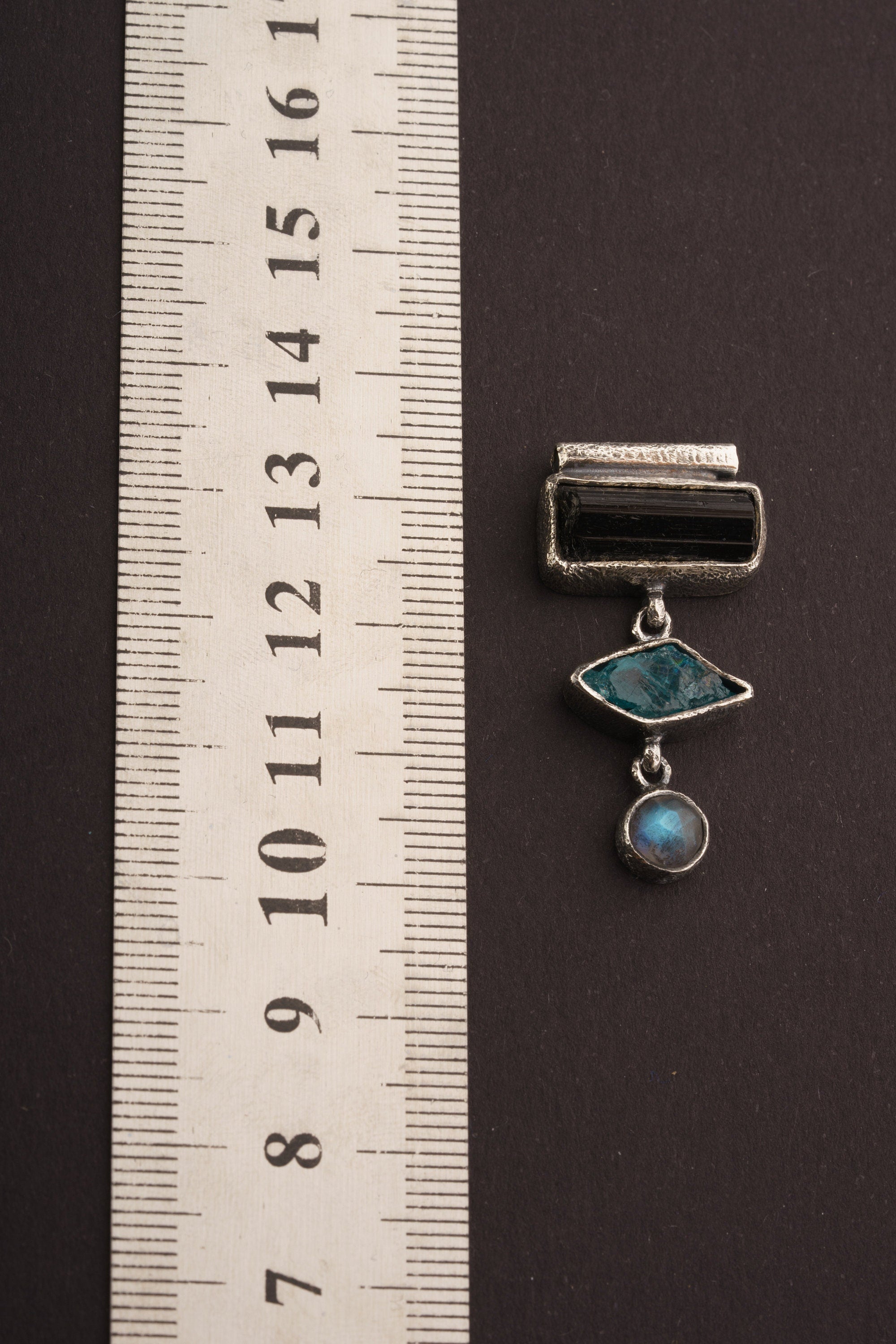 Grounding Vision Stack Pendant shown beside a ruler for scale, measuring approximately 4.5 to 5 cm long.