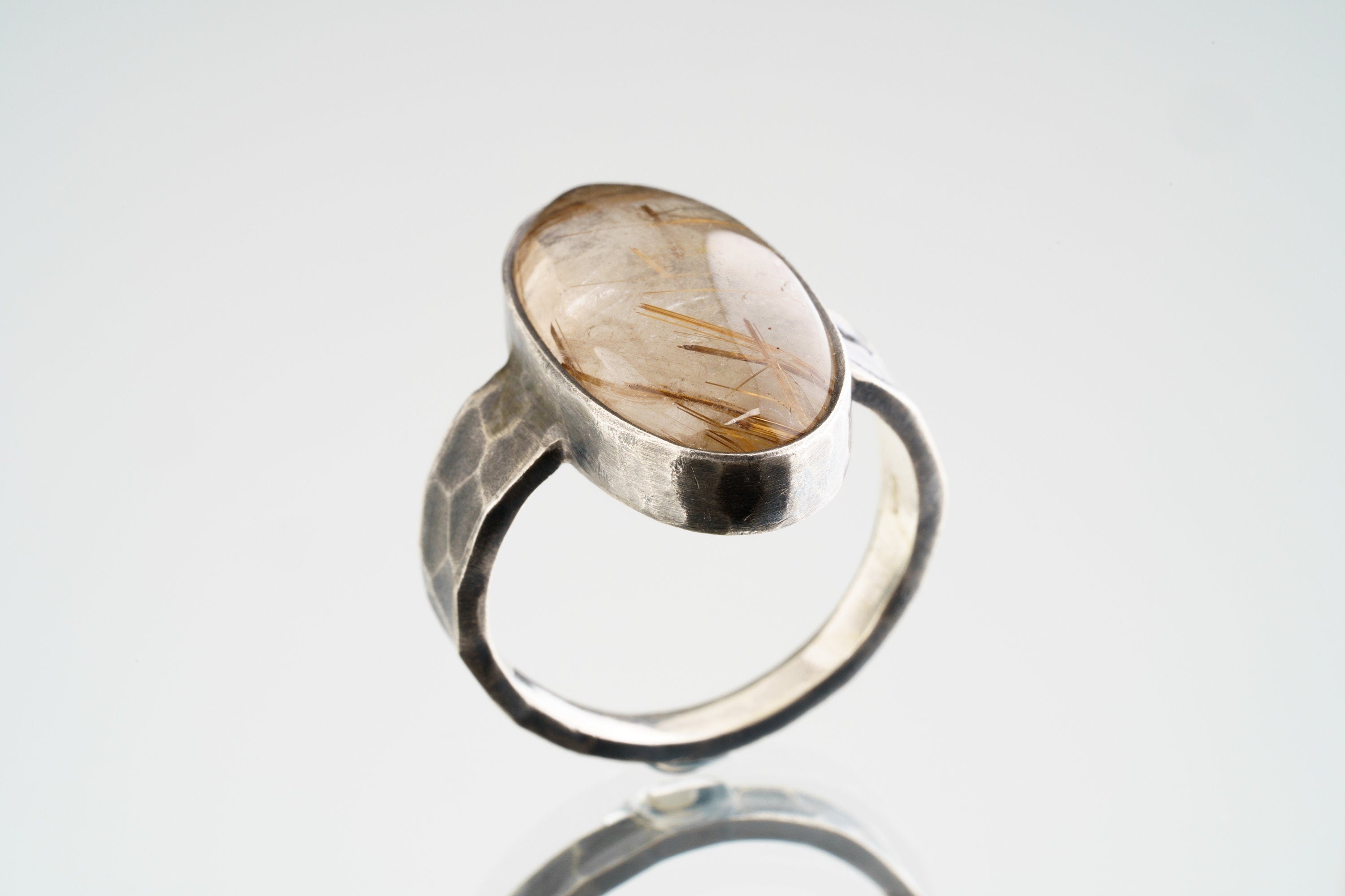 Side view of Rutilated Quartz ring showing raised bezel setting, hammered oxidized silver, and strong ring profile.