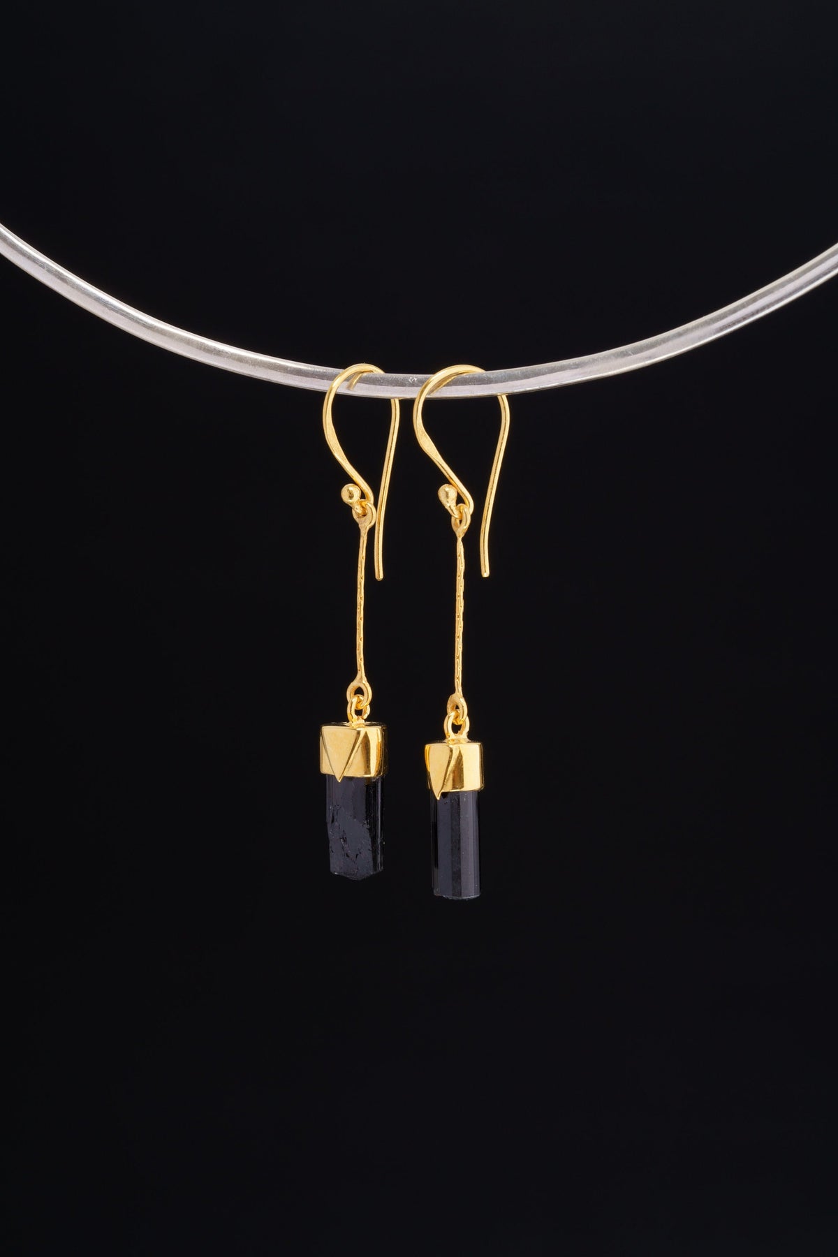 Black Tourmaline dangle earrings in gold-plated 925 sterling silver displayed on a silver choker with dark crystal drops.