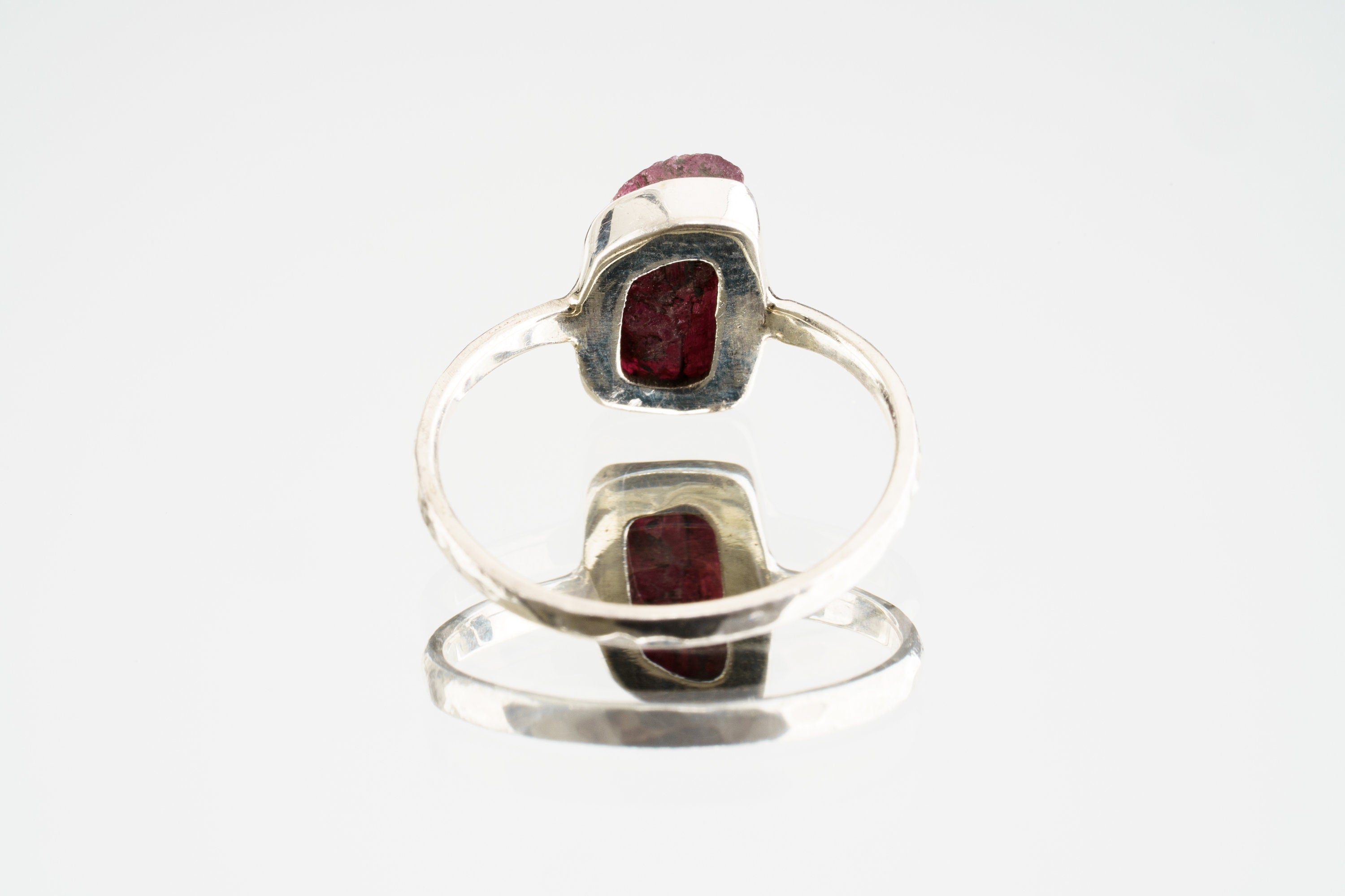 backview of handmade Pink Tourmaline ring showing the rose gemstone face, polished sterling silver setting, and solid band.