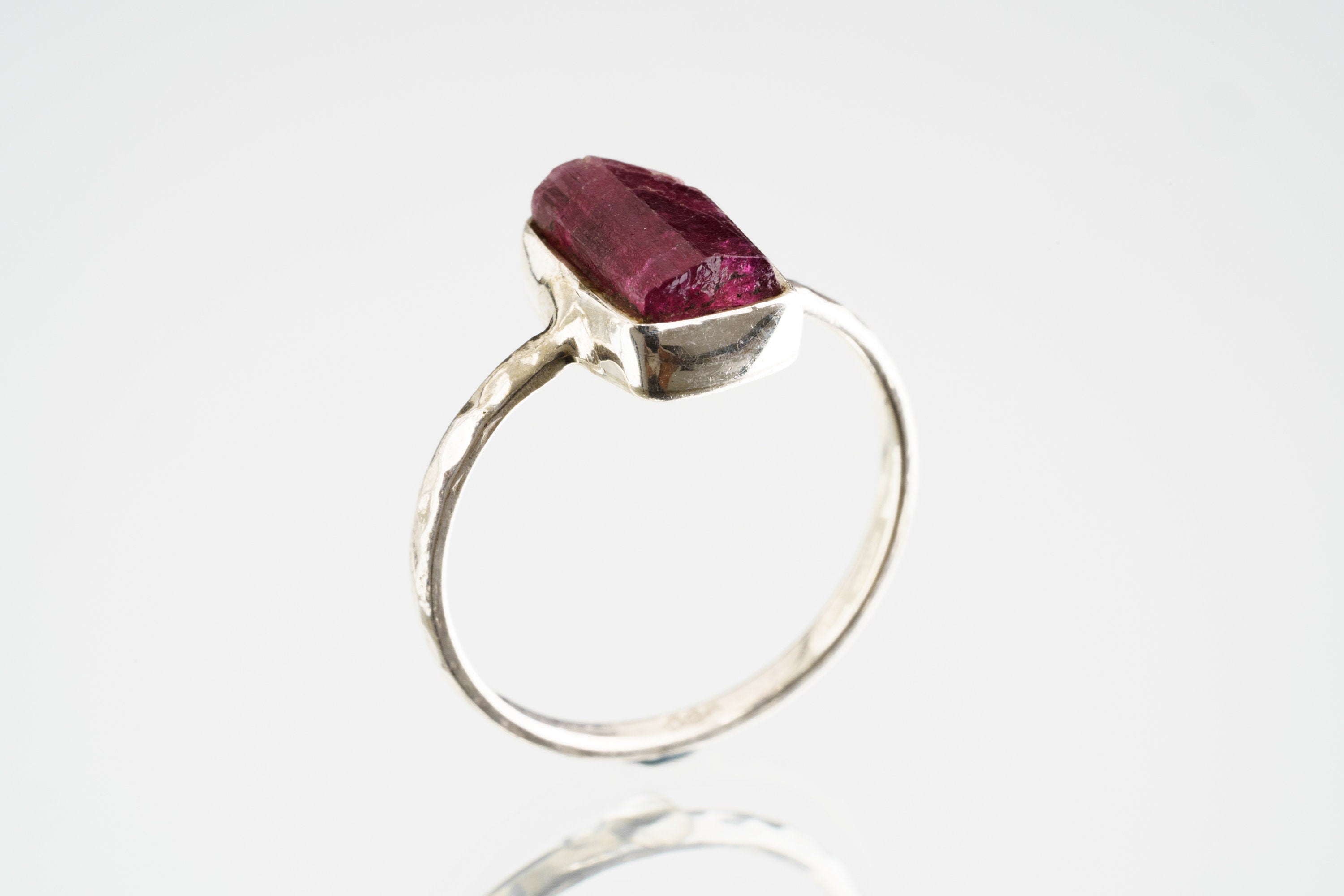 Side view of natural Pink Tourmaline ring showing the raised rose stone, handmade sterling silver setting, and band profile.