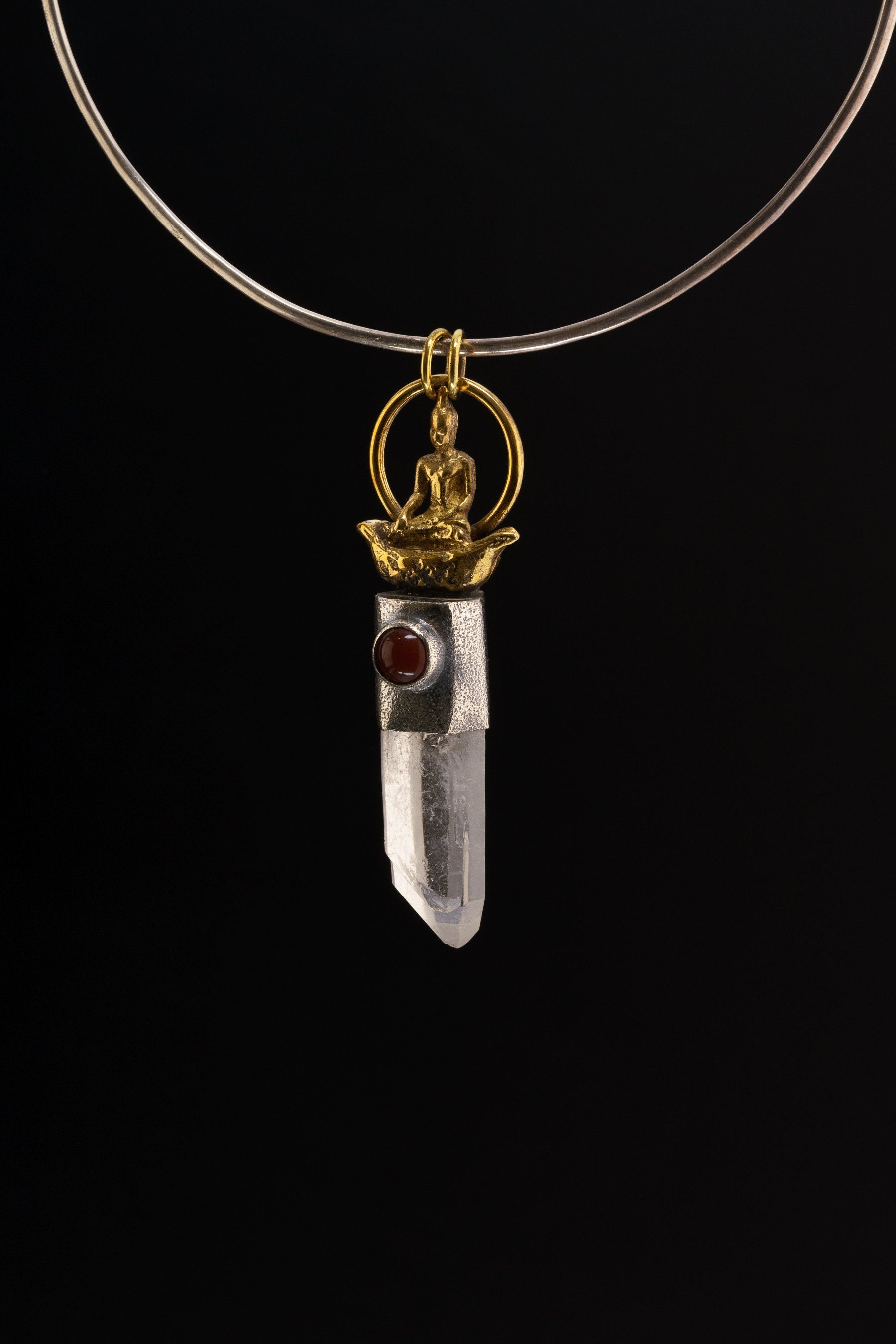 Raft Parable Carnelian Quartz pendant shown on a black background with sterling silver setting and symbolic crystal design.
