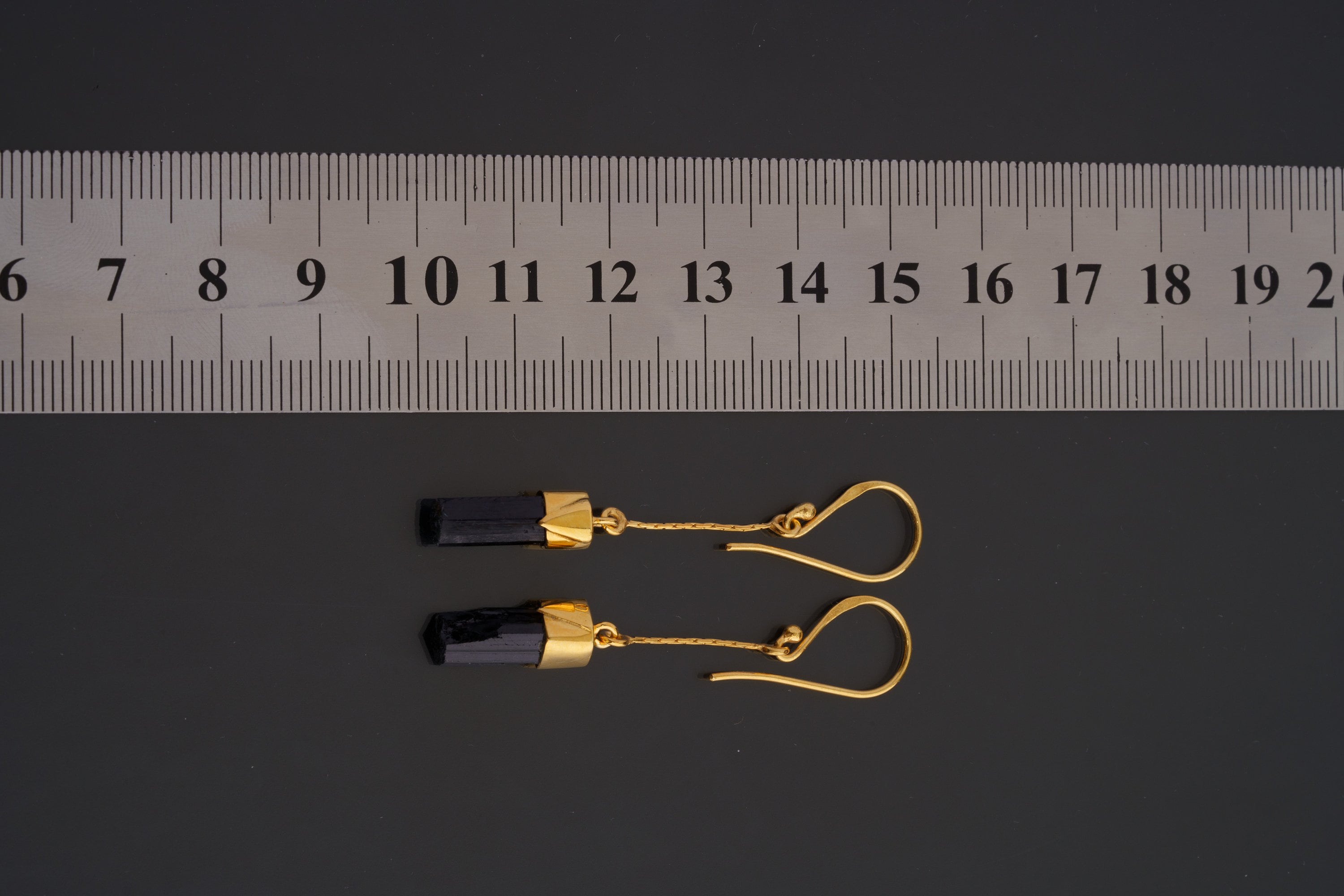 Black Tourmaline earrings shown beside a ruler for scale, with gold-plated sterling silver hooks and slim crystal drops.