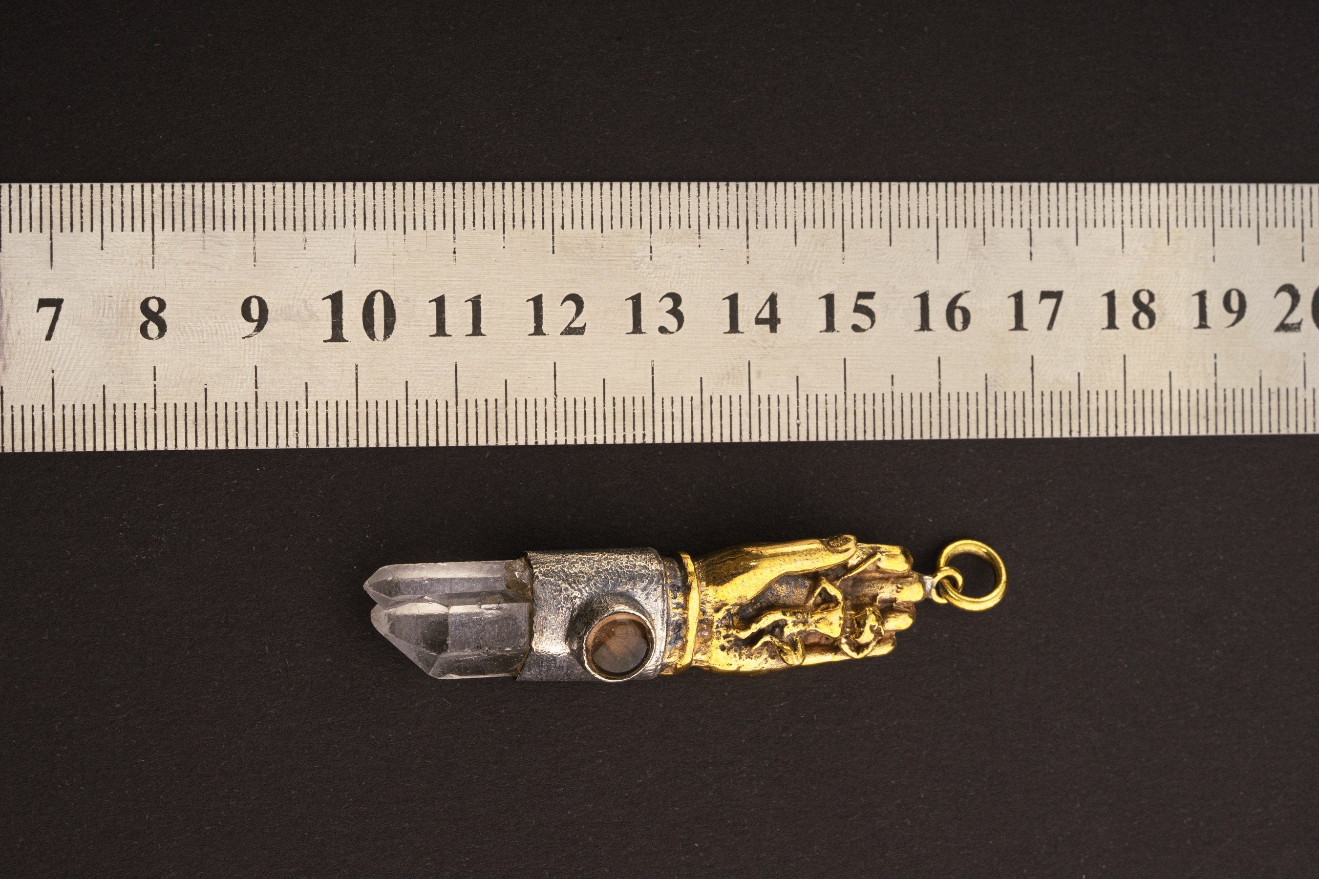 Sun Wukong Buddha Hand Clear Smoky Quartz pendant shown beside a ruler for scale with symbolic sterling silver setting.