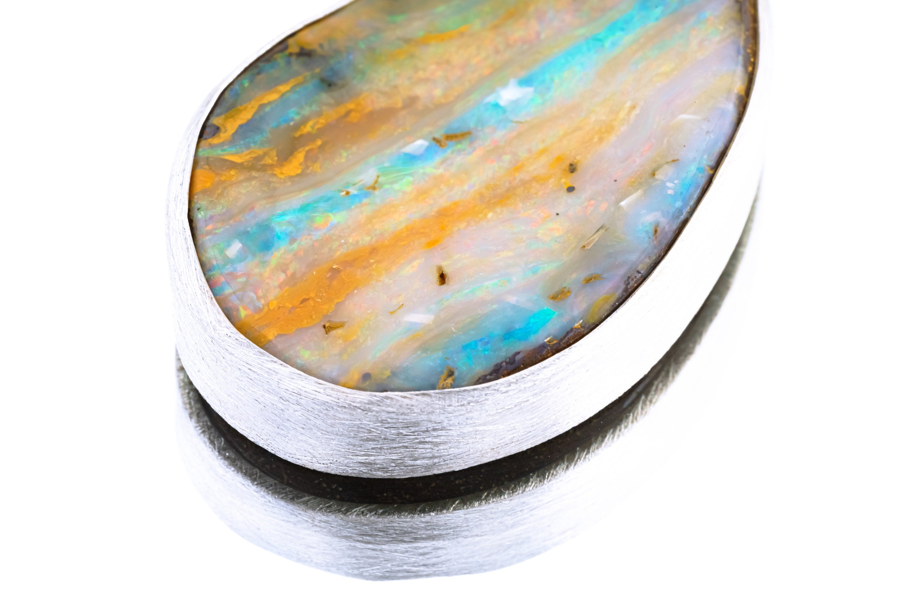 Close-up of solid Lightning Ridge Boulder Opal showing blue, green, gold, and orange colour play in textured silver bezel.