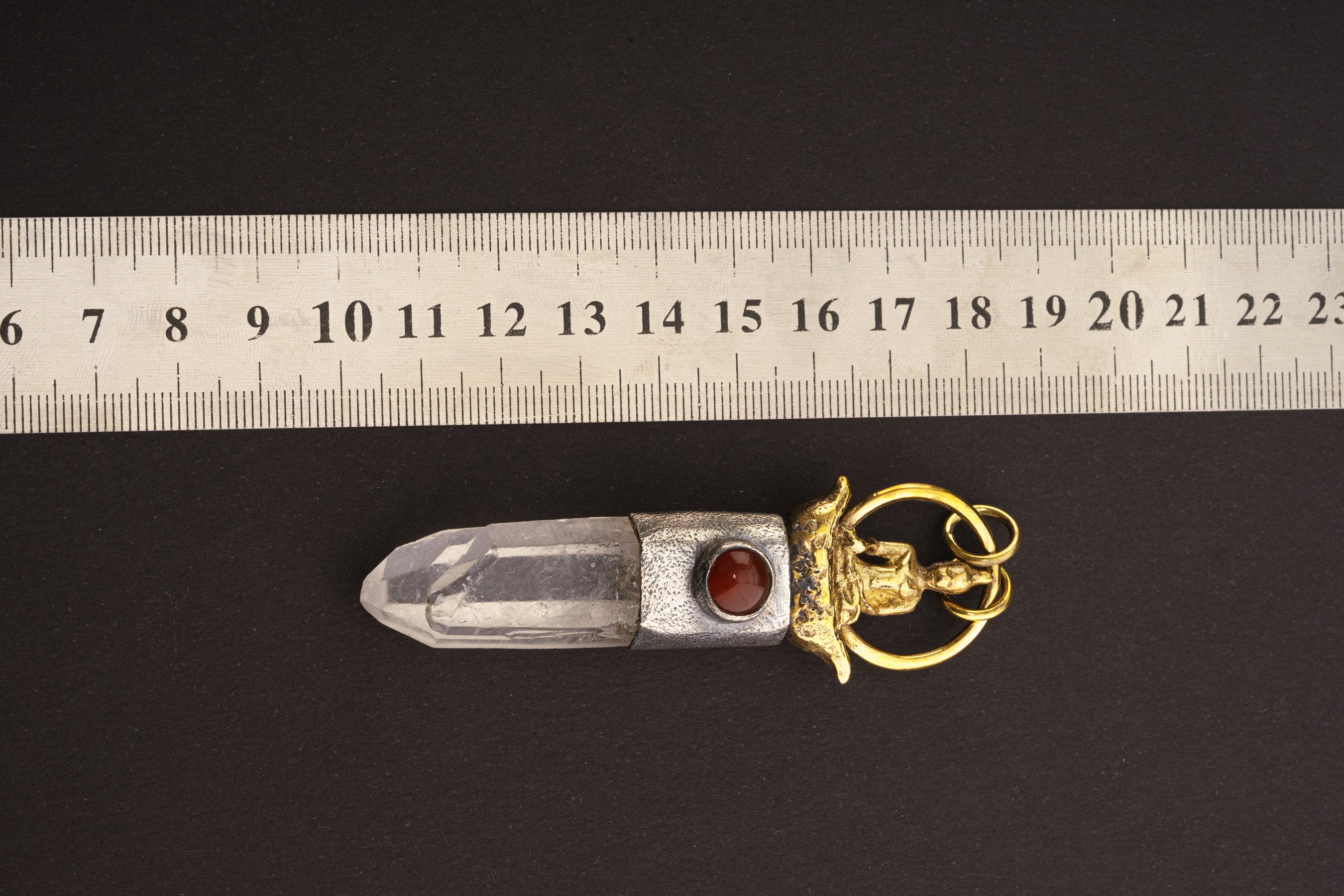 Raft Parable Carnelian Quartz pendant shown beside a ruler for scale with sterling silver and adjustable necklace styling.