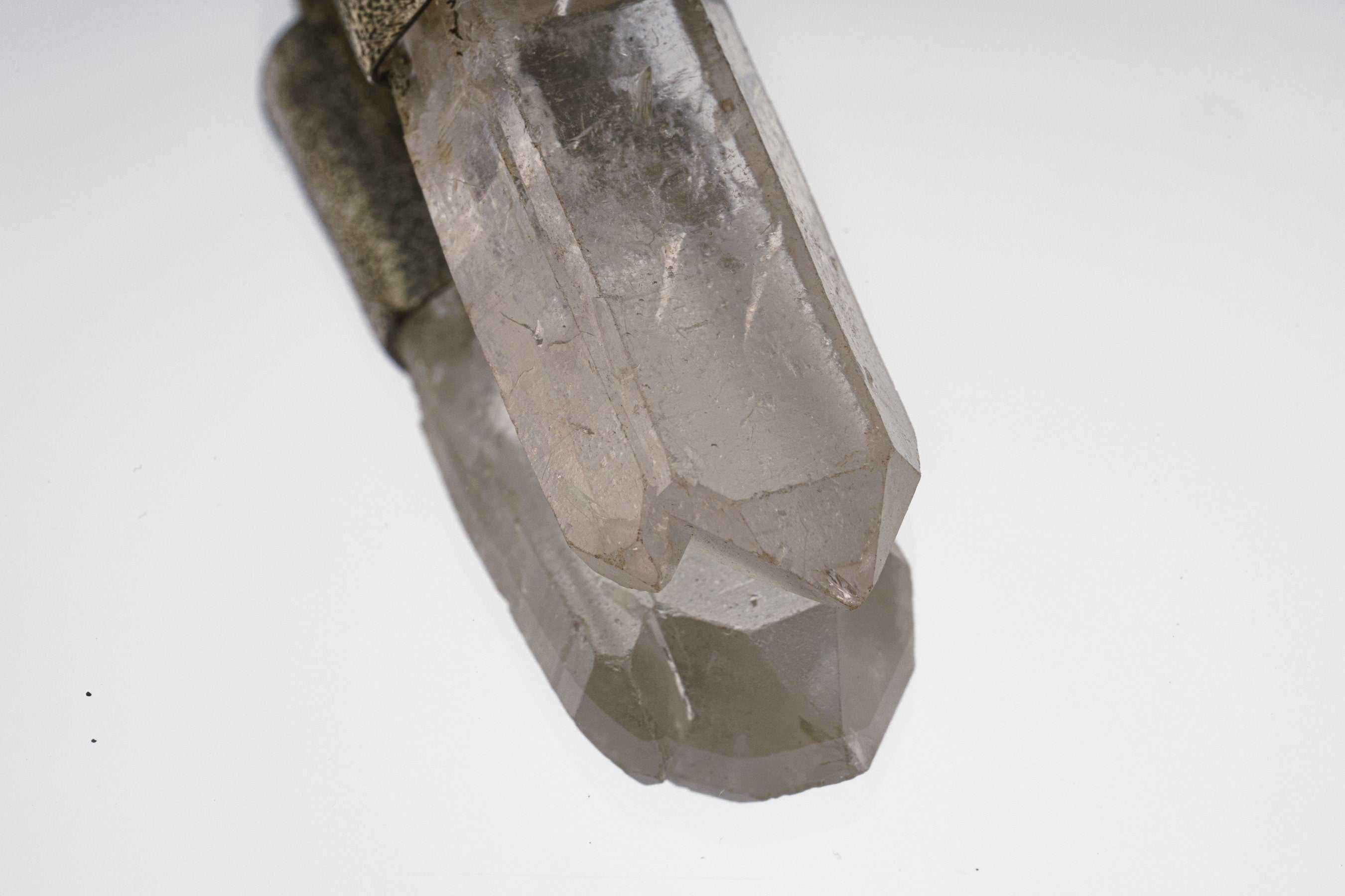Close-up of Clear Quartz crystal point in a Rooster Carnelian talisman pendant with handmade metal detail.