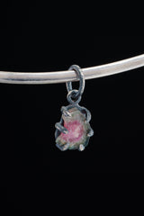 Watermelon Tourmaline Claw Pendant on black background with oxidized sterling silver and natural pink-green crystal.