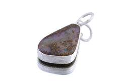 Lightning Ridge Boulder Opal pendant on white background with freeform opal face and handmade sterling silver bezel.