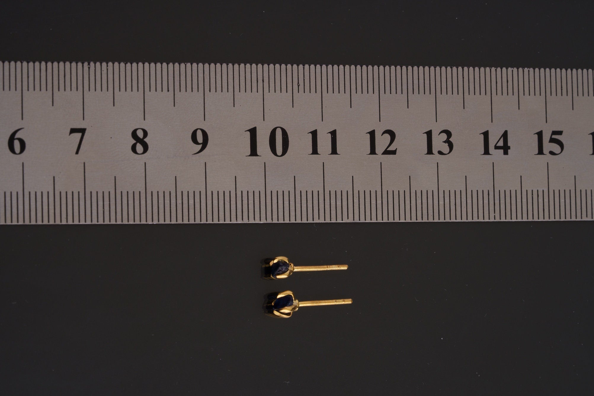 Australian Sapphire gold-plated stud earrings shown beside a ruler for size reference.