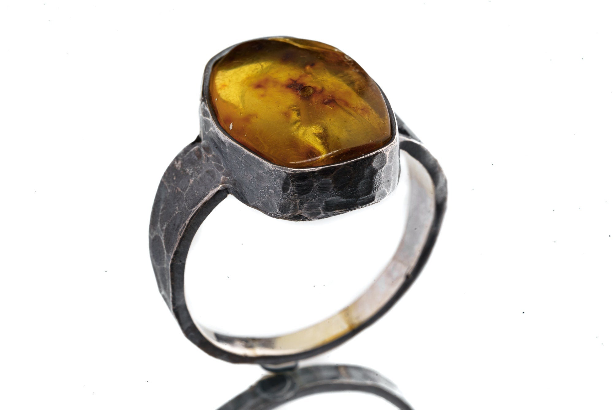 Side view of Amber ring showing oxidized hammered silver texture, raised bezel setting, and strong masculine profile.