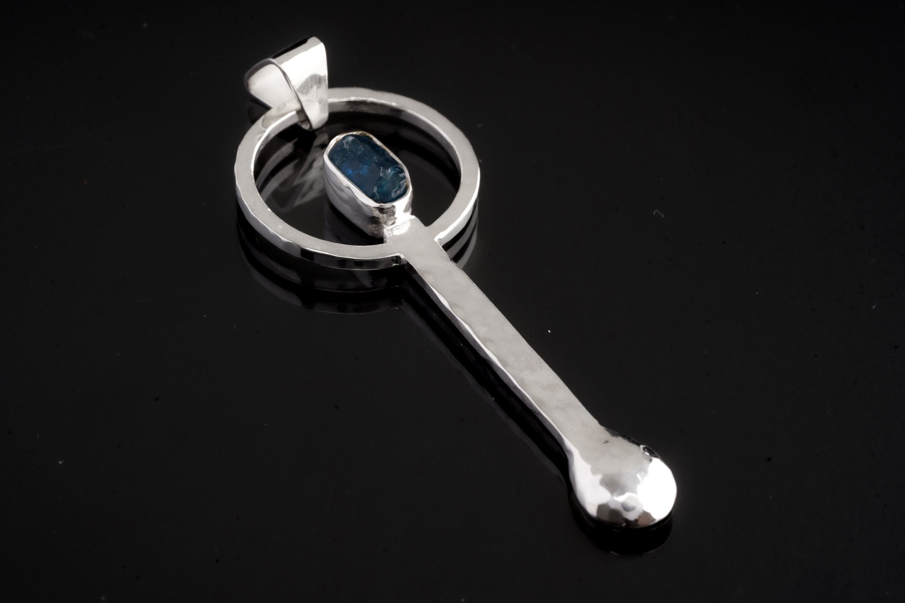 Blue Apatite sterling silver ritual spoon shown on dark background with hand-hammered silver and blue gemstone setting.