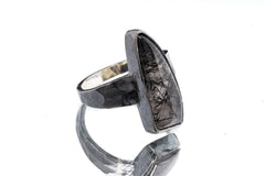 Side view of Rutilated Quartz oxidized silver ring showing long crystal form and rugged hammered band texture.