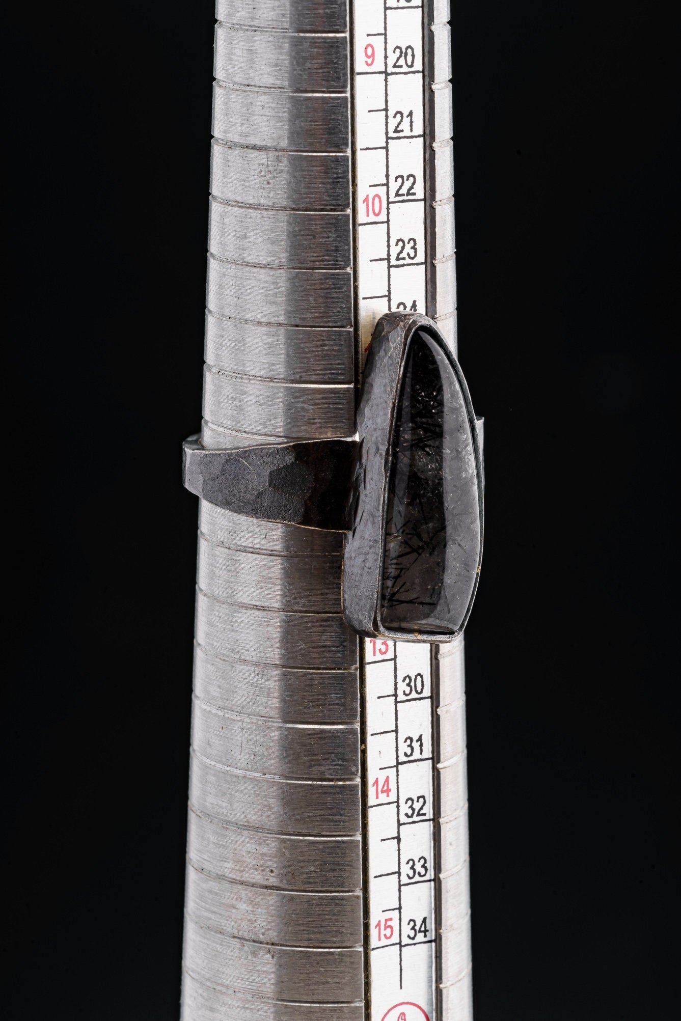 Rutilated Quartz oxidized silver ring shown beside a ruler for scale, with long crystal setting and rugged silverwork.