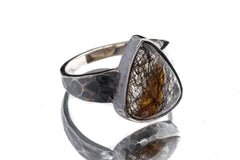Rutilated Quartz ring in oxidized 925 sterling silver with hammered texture and open-back bezel setting.