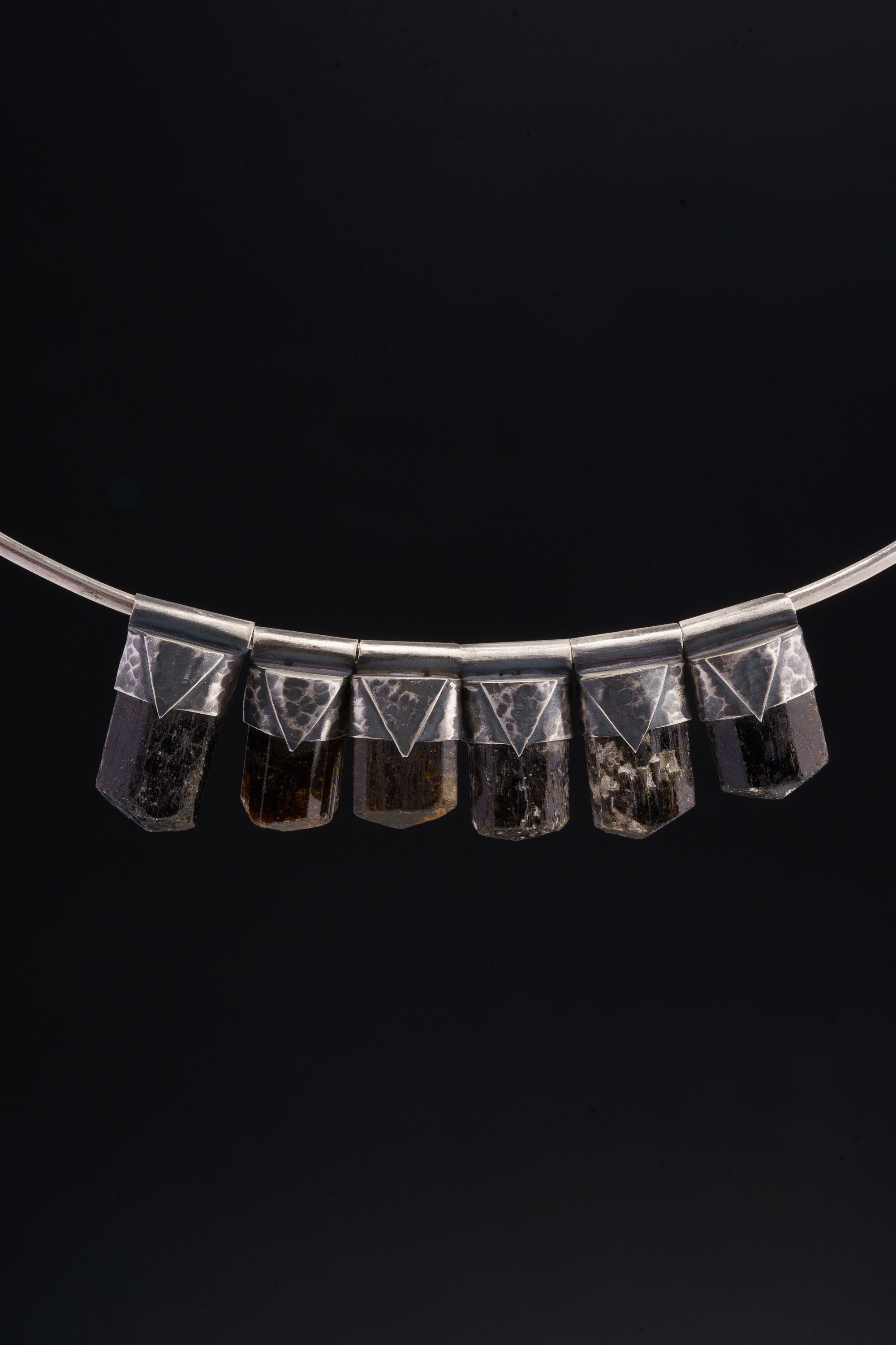 Himalayan Dravite Tourmaline Stack Pendants shown together on black background with oxidized silver caps and smoky brown-black stones.