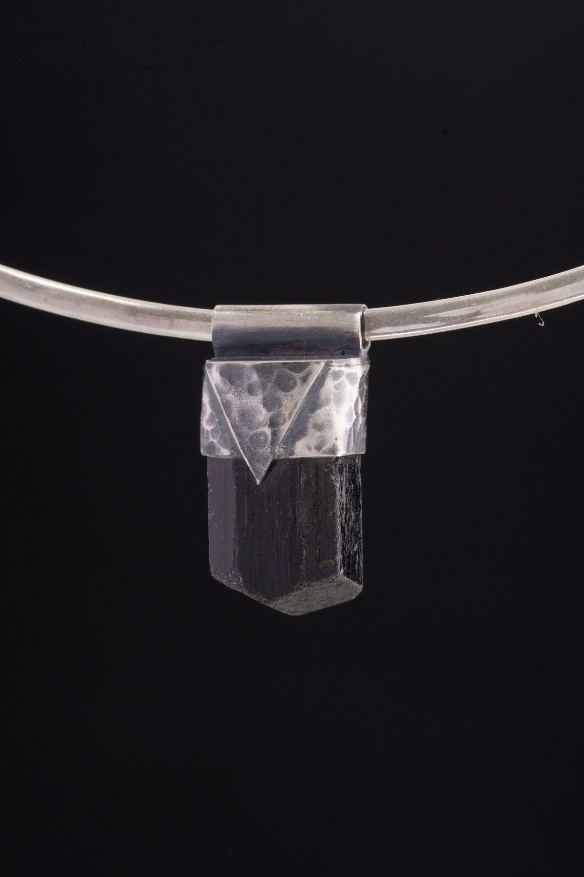 Himalayan Dravite Tourmaline Stack Pendant shown on black background with oxidized sterling silver cap and dark terminated crystal.