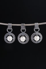 Collection of oxidized 925 sterling silver South Sea Pearl claw pendants with rugged handmade texture on a dark background.