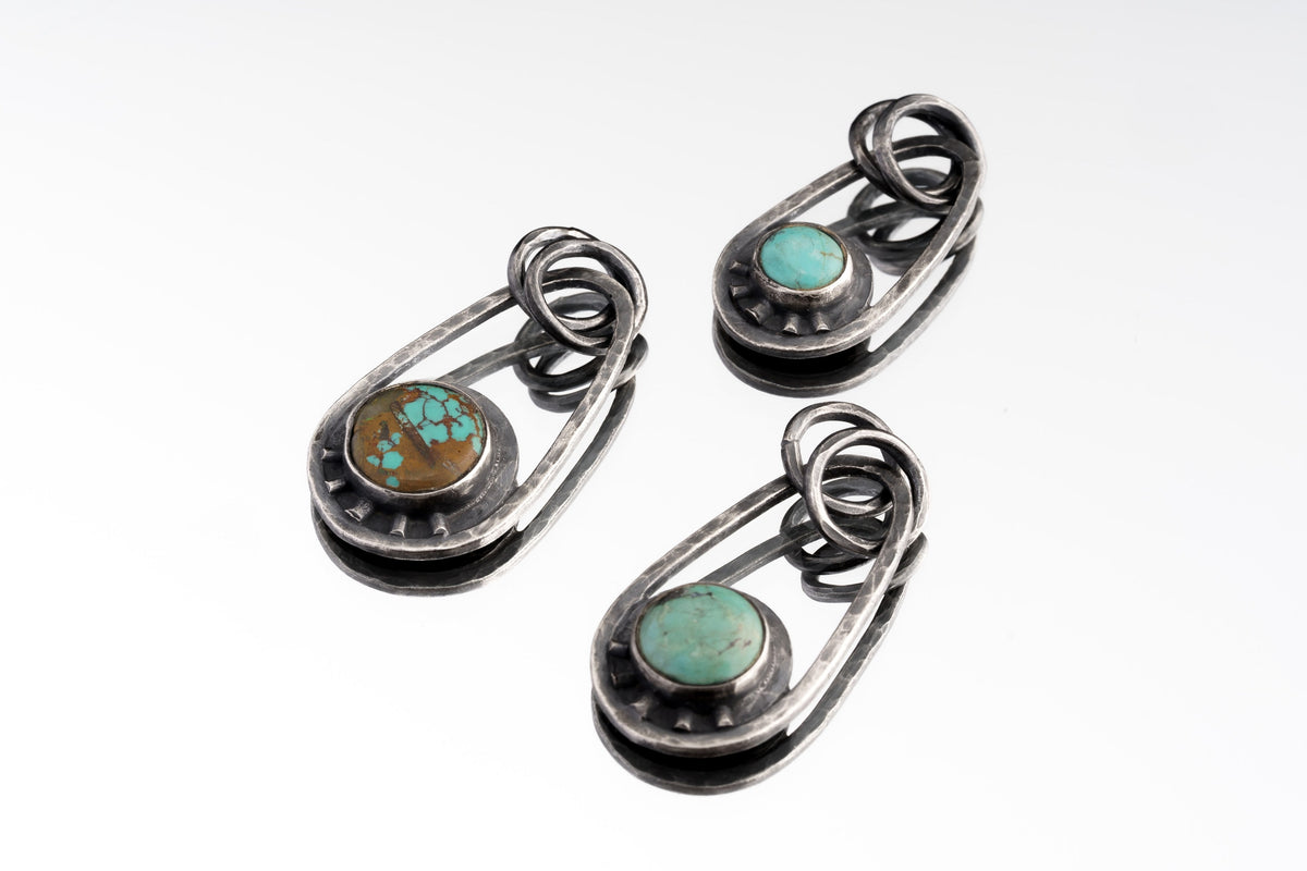 Three Royston Turquoise Cosmic Ray pendants in oxidized 925 sterling silver, showing blue-green stones and celestial ray details.