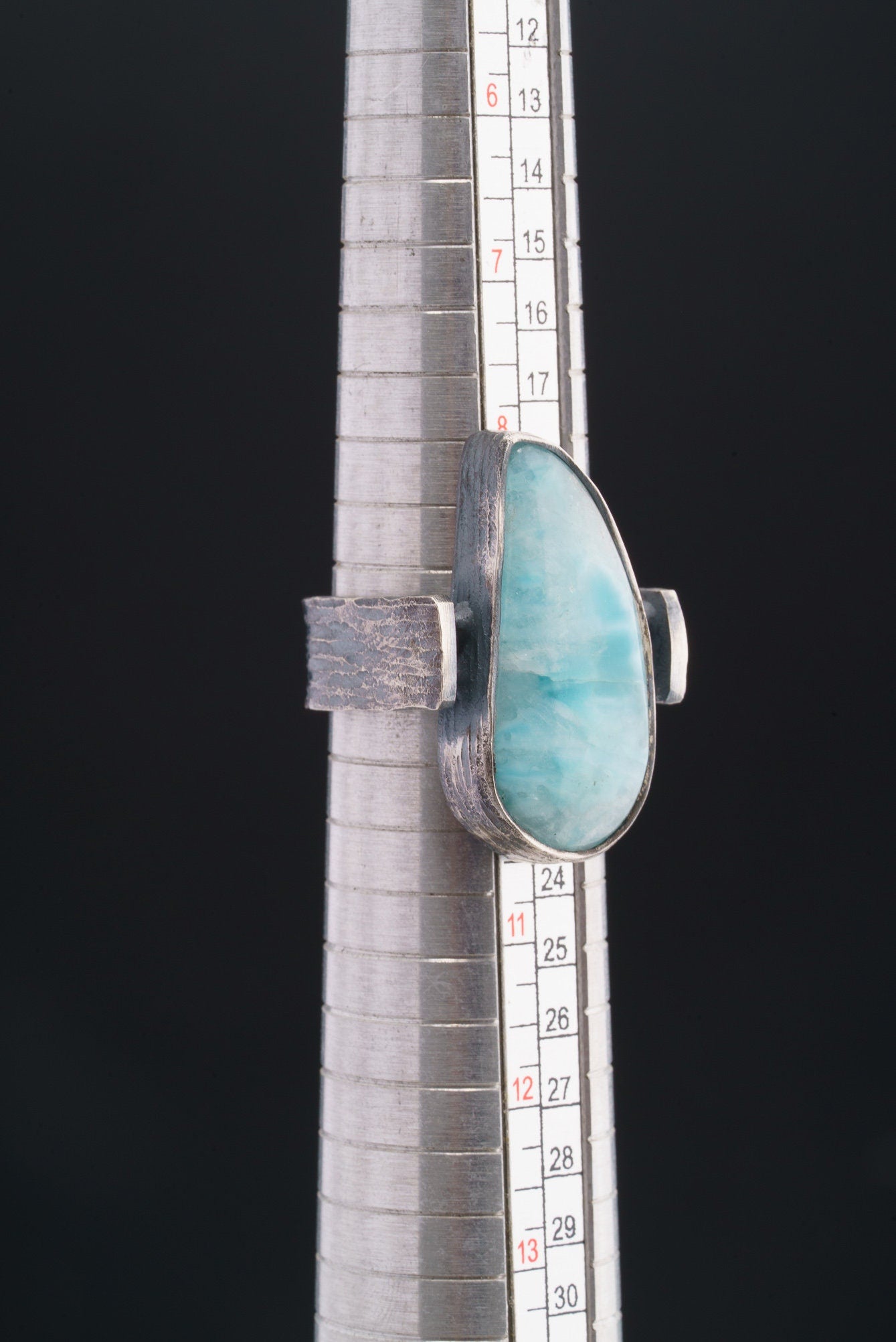 Larimar oxidized silver ring shown beside a ruler for scale, with rugged hammered 925 sterling silver construction.