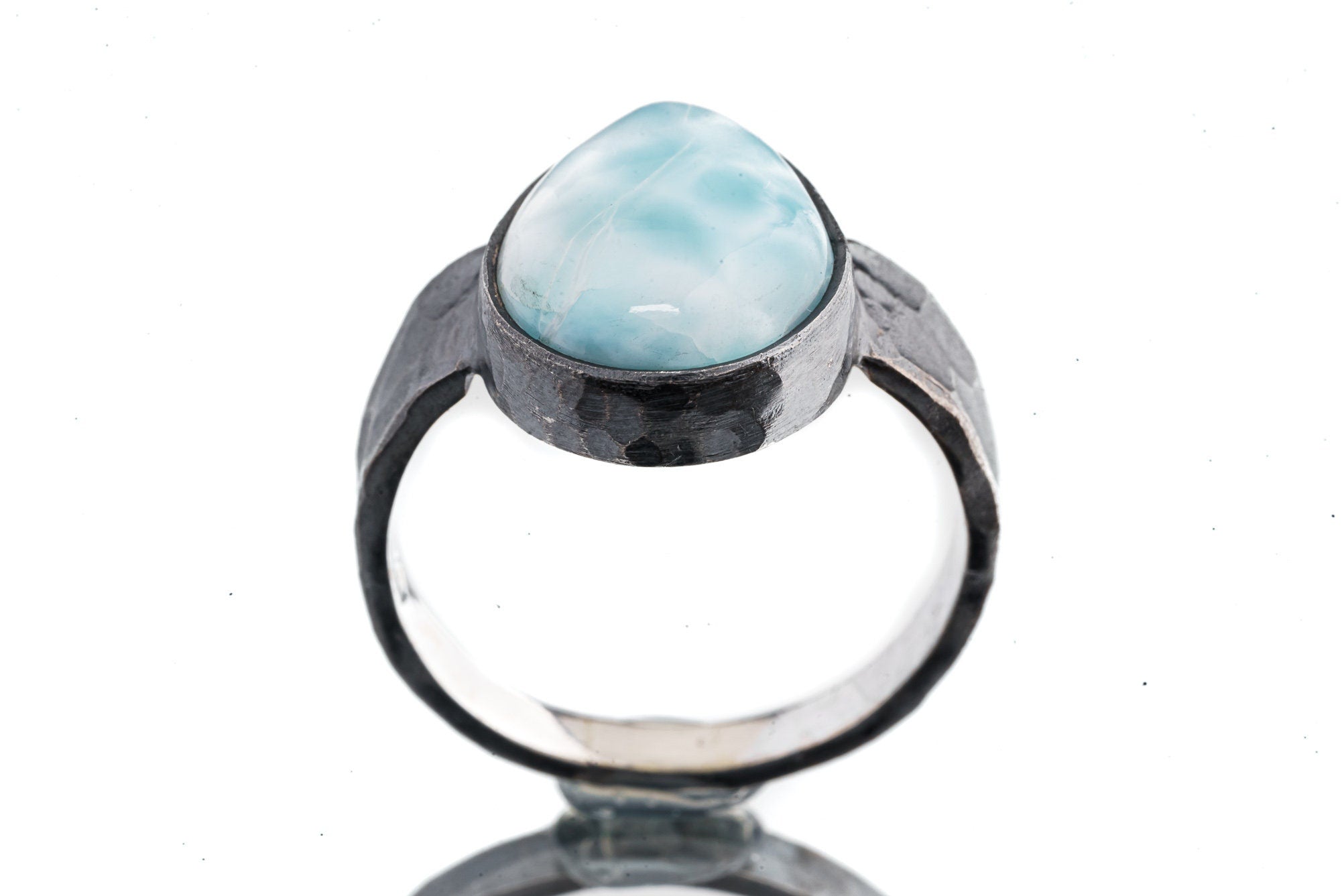 Front view of Larimar ring showing pale blue pectolite stone in dark oxidized sterling silver with open-back setting.