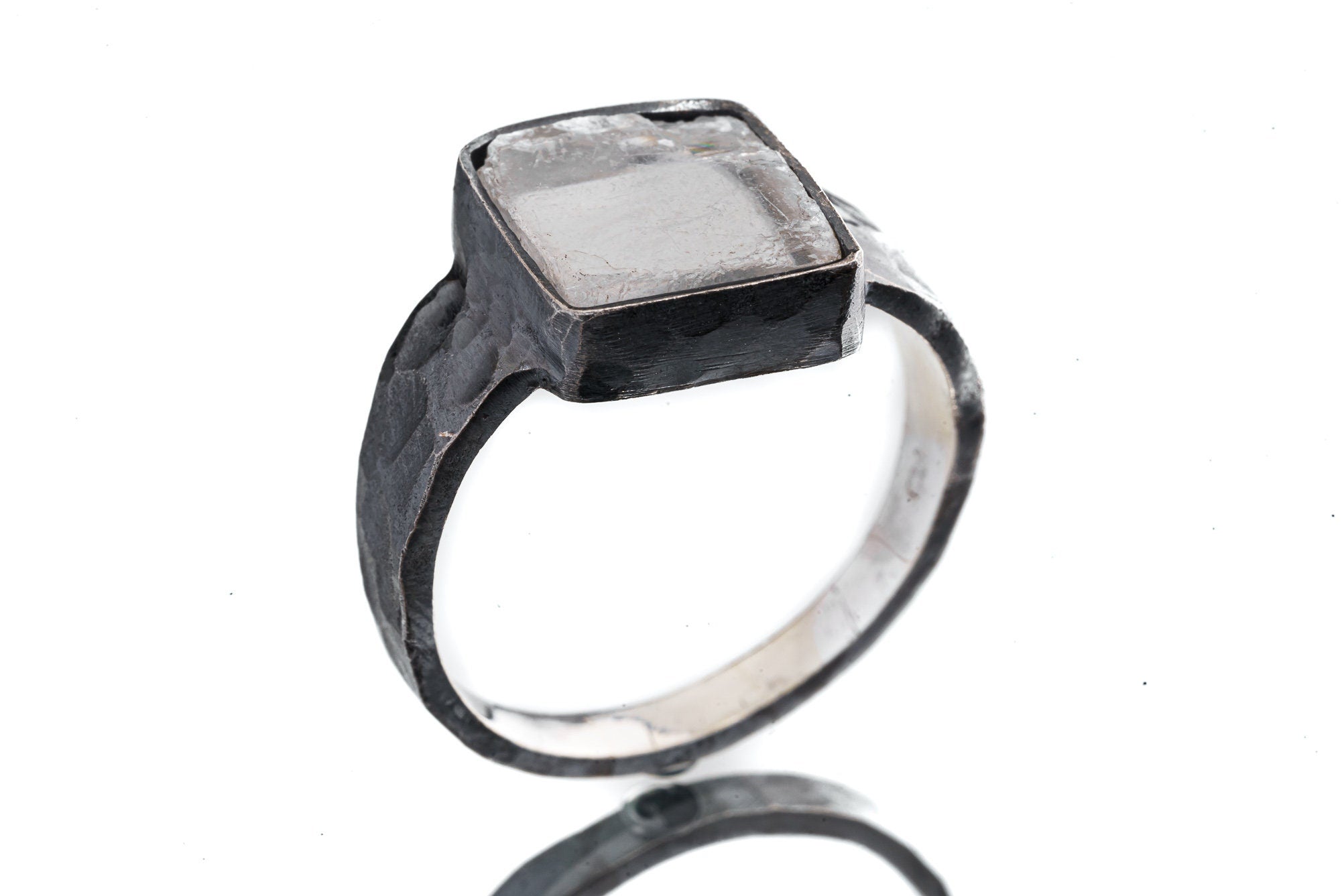 Selenite ring shown from the side with hammered oxidized silver, raised bezel setting, and polished highlights.