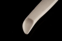 Close-up of antique bone spoon pendant tip showing carved scoop form and natural bone surface.
