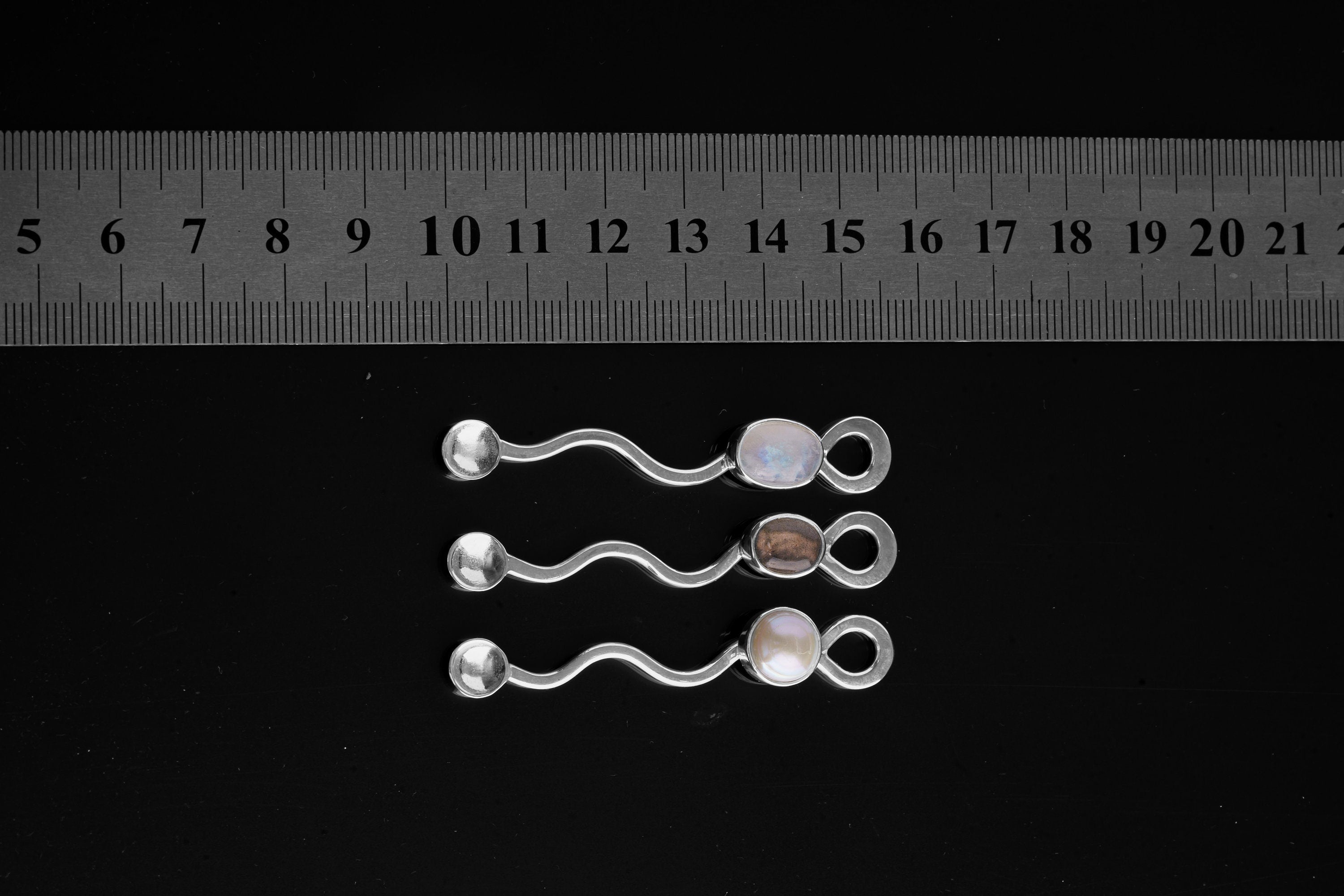 South Sea Pearl spoon pendant shown beside a ruler for scale, with polished sterling silver and Pearl setting.