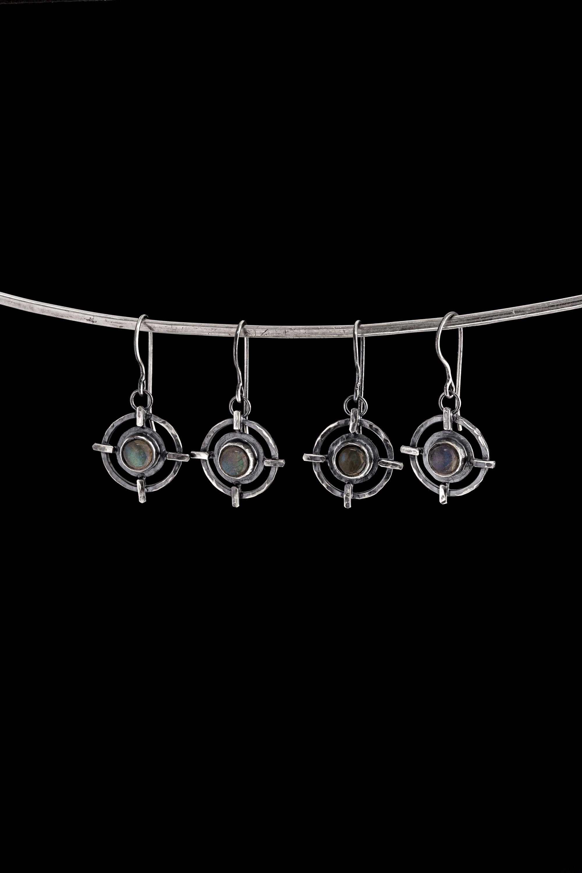Labradorite earrings displayed on a silver choker, showing circle cross dangle shapes and natural gemstone flash.