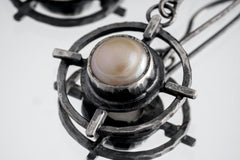 Close-up of South Sea Pearl earring showing rustic hammered silver texture and symbolic layered setting.