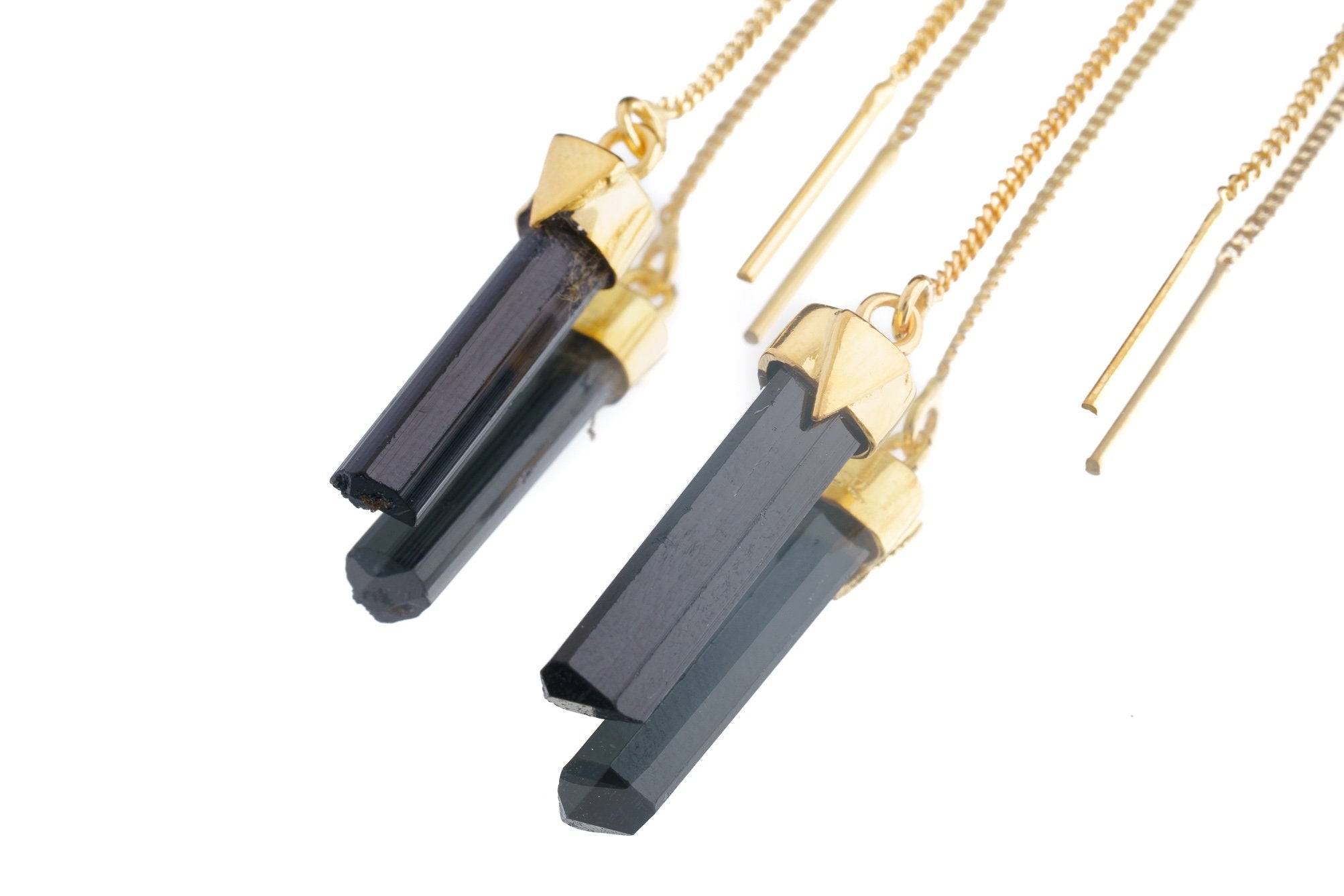 Close-up of gold-plated Tourmaline earrings showing dark crystal drops, fine hook fittings, and warm gold finish.