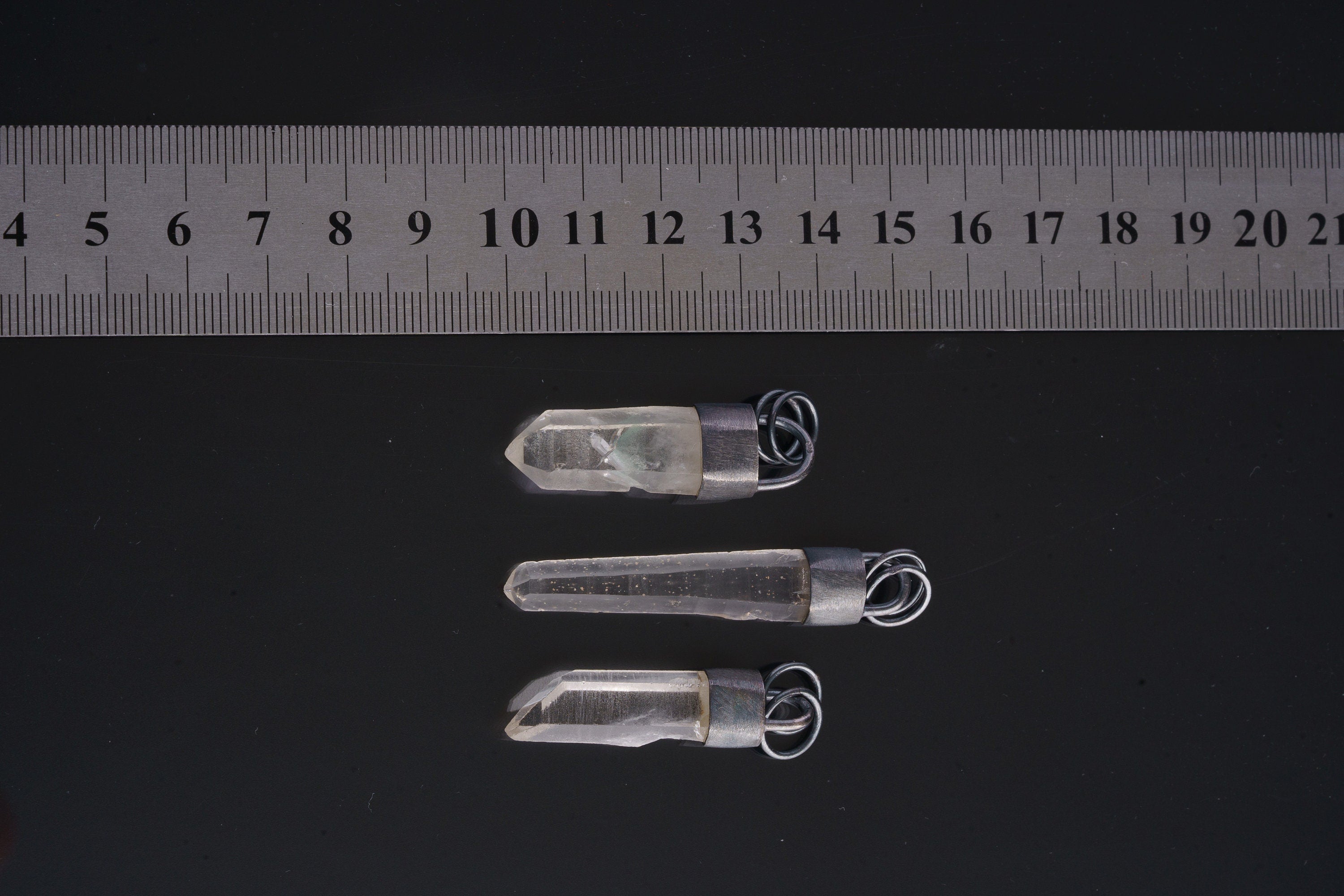 Australian Clear Quartz point pendants shown beside a ruler for scale, measuring approximately 4.5 to 5 cm long.