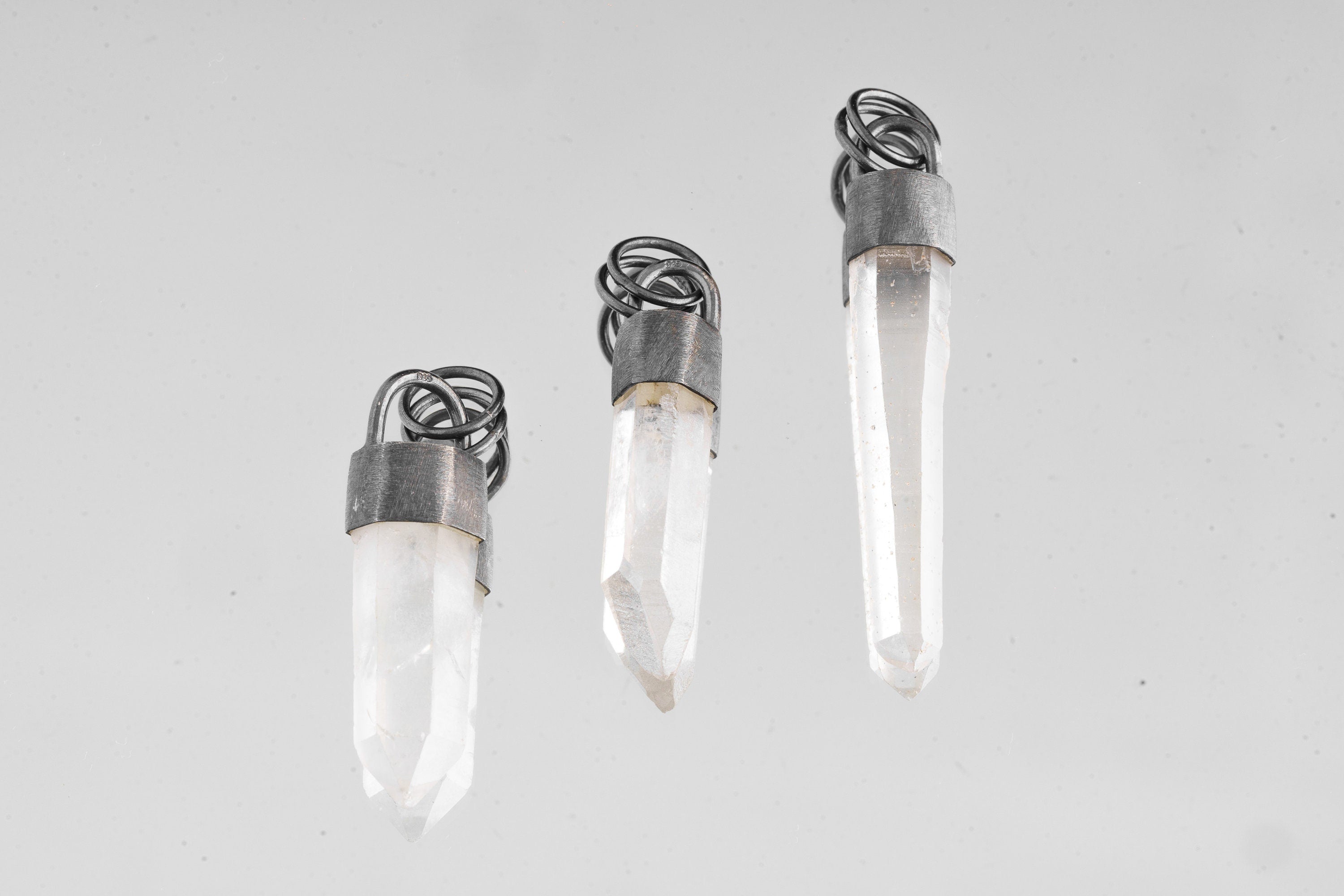 Three Australian Clear Quartz point pendants in oxidized sterling silver, showing natural variation in crystal length and shape.