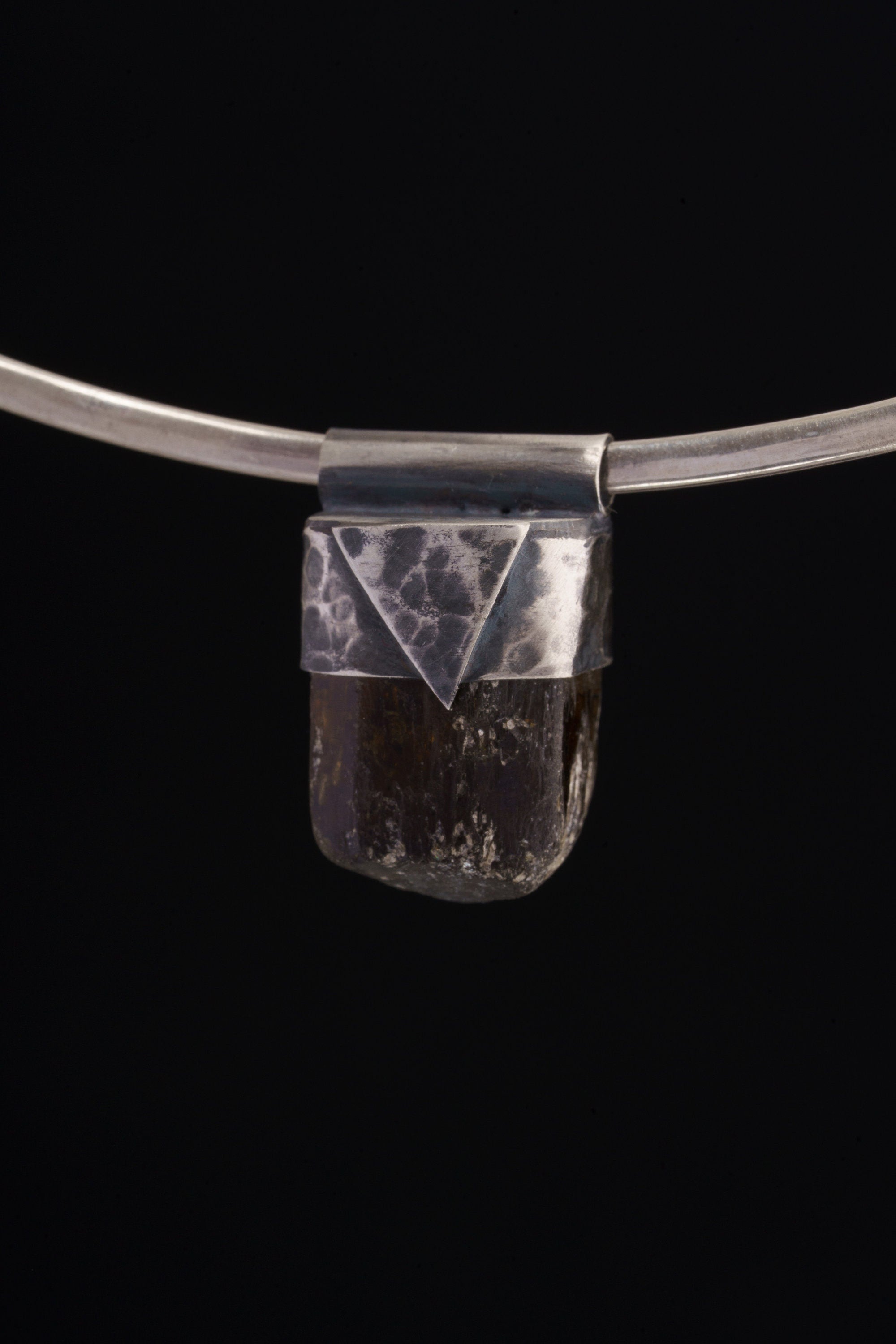 Himalayan Dravite Tourmaline Stack Pendant shown on black background with oxidized 925 silver cap and dark crystal body.