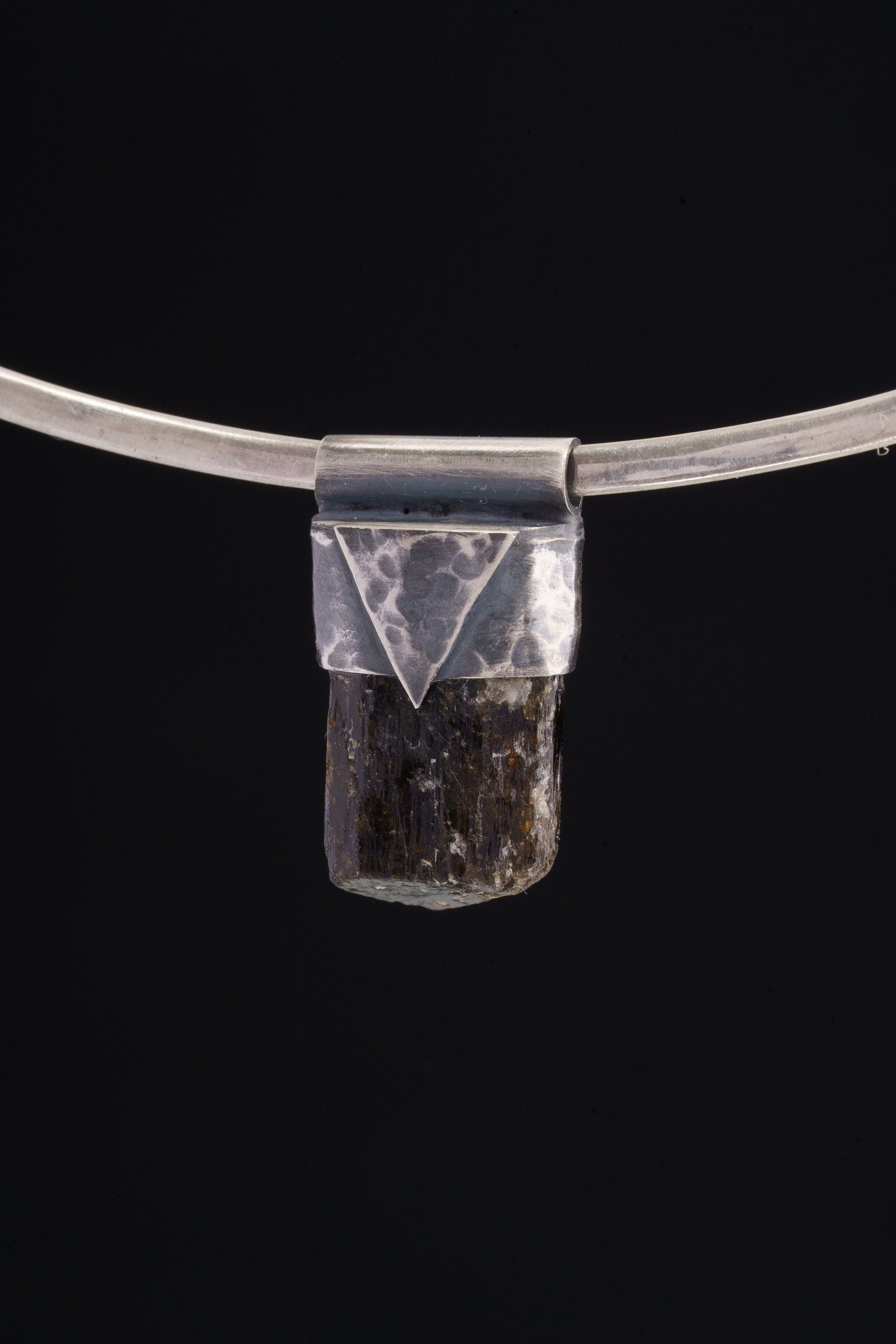 Himalayan Dravite Tourmaline Stack Pendant shown on black background with oxidized sterling silver cap and dark terminated crystal.
